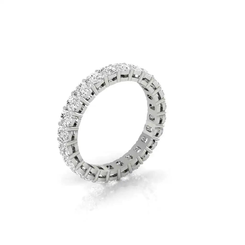 The Full Diamond Eternity Ring, crafted in silver, showcases a continuous row of round-cut gemstones with VS clarity in a prong setting. It is elegantly displayed at a slight angle against a plain white background.