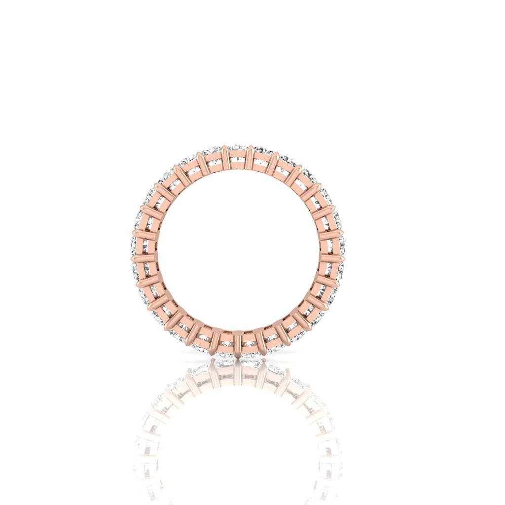 The Full Lab Grown Diamond Eternity Ring, crafted from 18KT circular gold with alternating rose gold bands and F Color VS Clarity diamonds, showcases a delicate design on a glossy white surface, featuring an elegant seamless array of stones around the band.