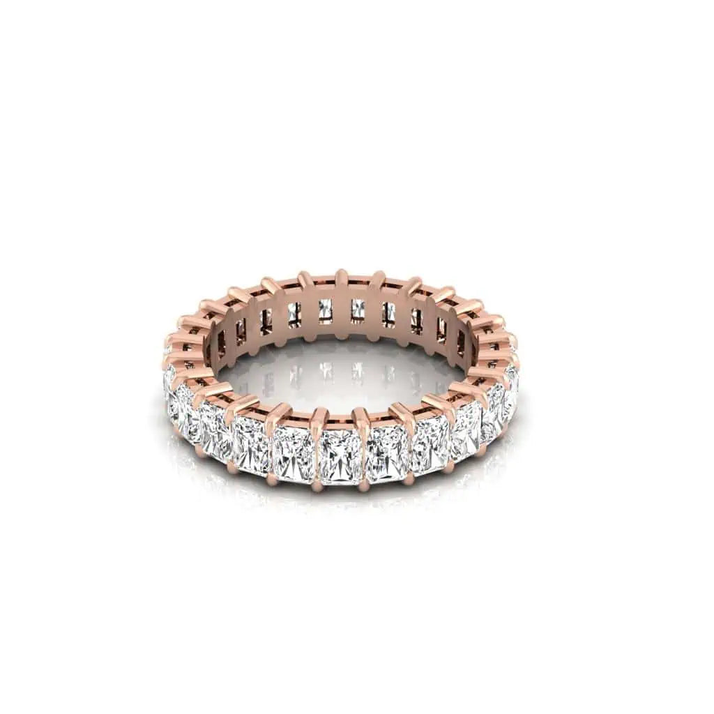 The Full Diamond Eternity Ring in 18KT rose gold showcases square-cut diamonds of F color and VS clarity, encircling the band. Set in shared prongs, this design offers a luxurious sparkle with its continuous circle of closely set gems.