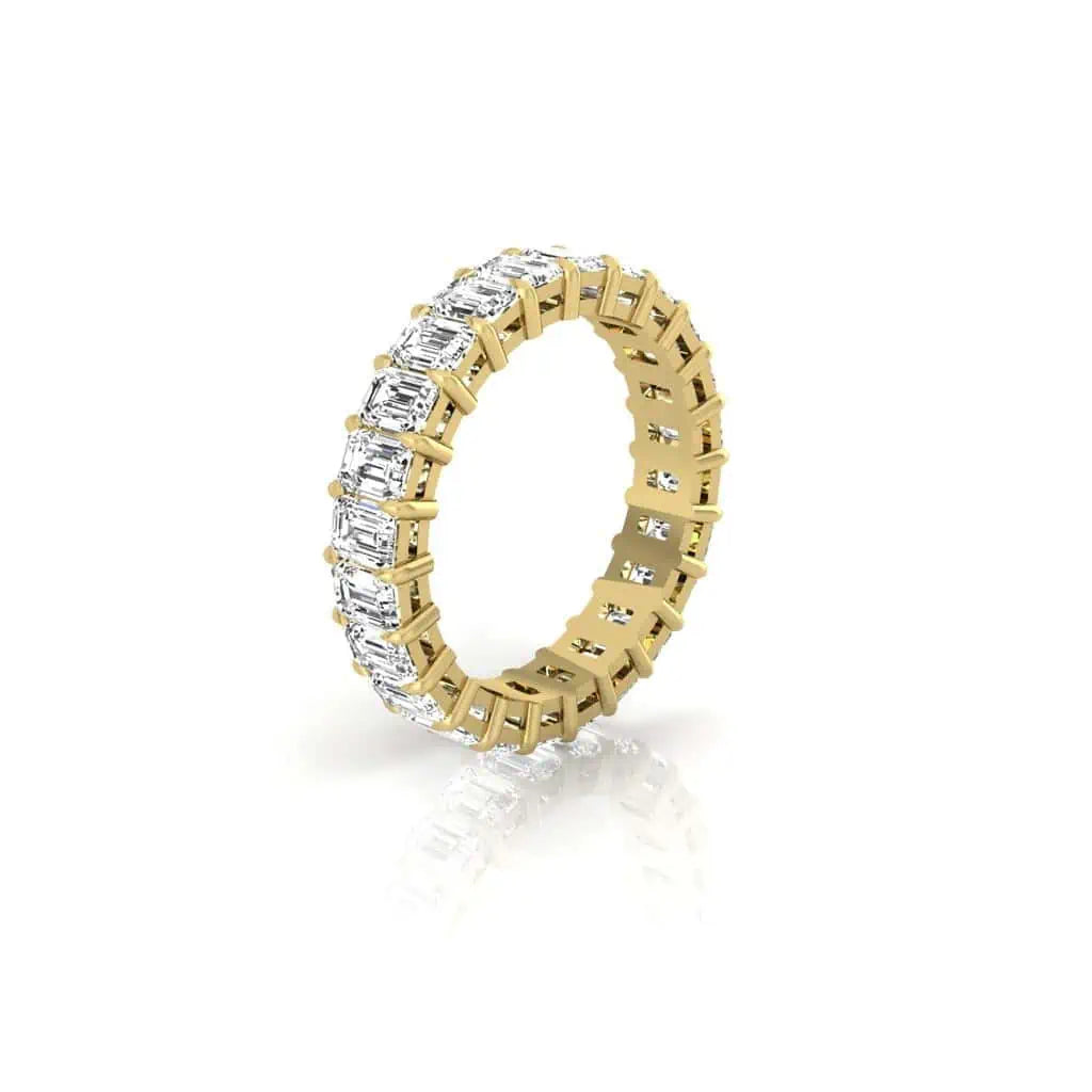 The Full Diamond Eternity Ring from Janet Heller Fine Jewelry, crafted in 18KT gold, features evenly spaced diamonds offered in various shapes and custom carat weights. The color of the diamonds is F and the clarity is VS. This is the perfect wedding band to be worn alone or stacked with your engagement ring.