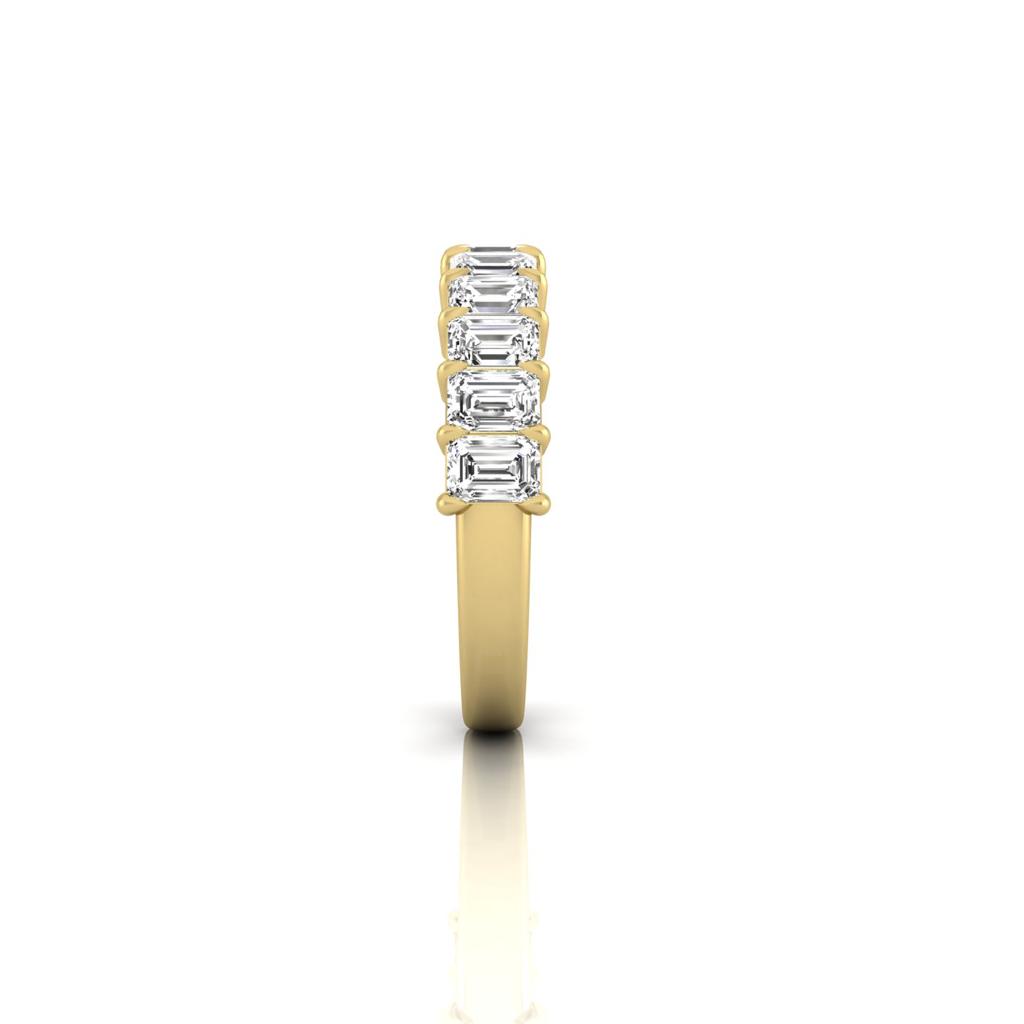 The Half Diamond Eternity Ring is crafted from 18KT gold, showcasing a row of five rectangular, clear gemstones with VS Clarity. The image presents the ring upright, displaying its sparkling gems and lustrous band against a plain white background.
