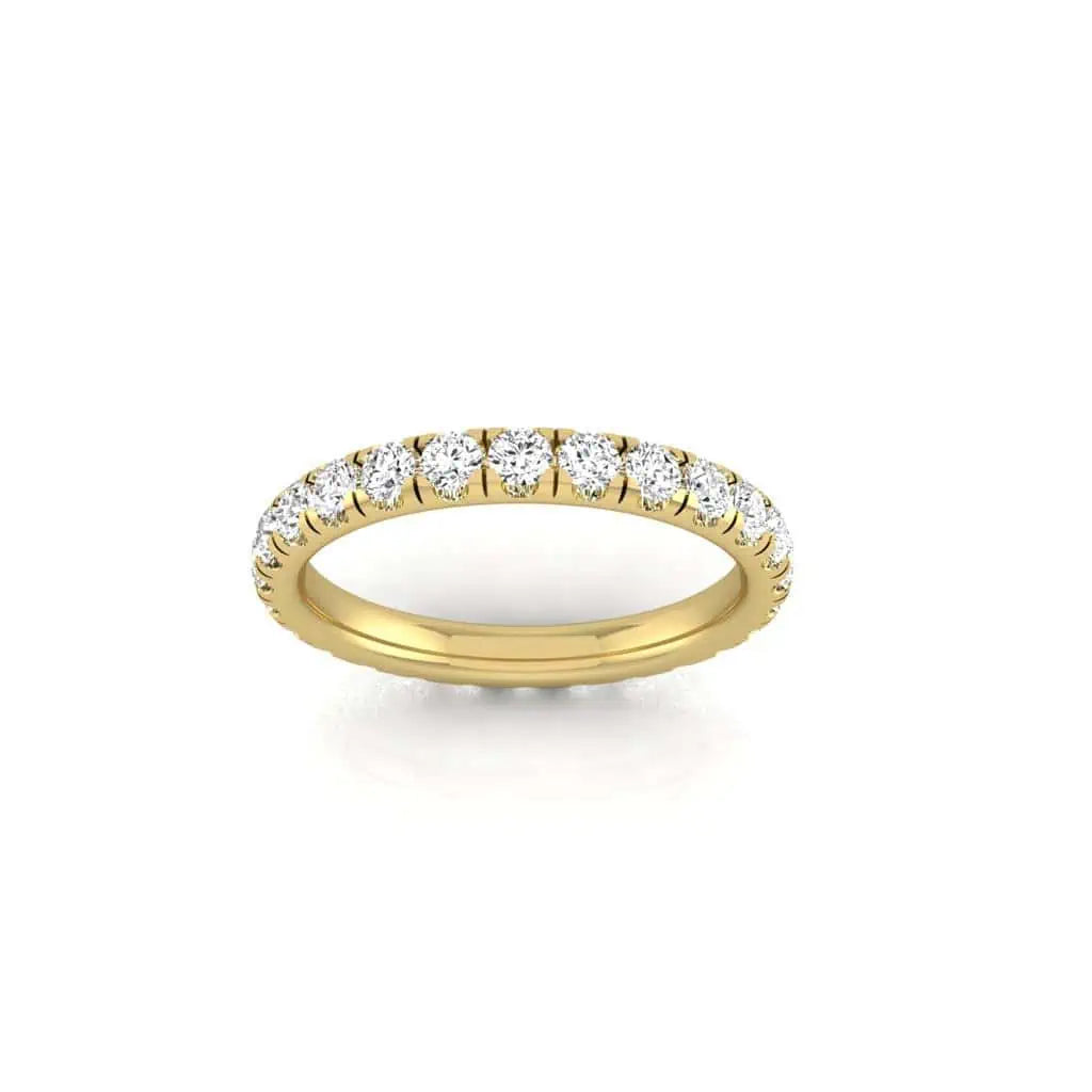The 1ct Round Diamond Eternity Ring is an exquisite piece, with a row of round, sparkling diamonds set in 18KT gold. The smooth, shiny band highlights the VS clarity gems, resting gracefully against a plain white background.