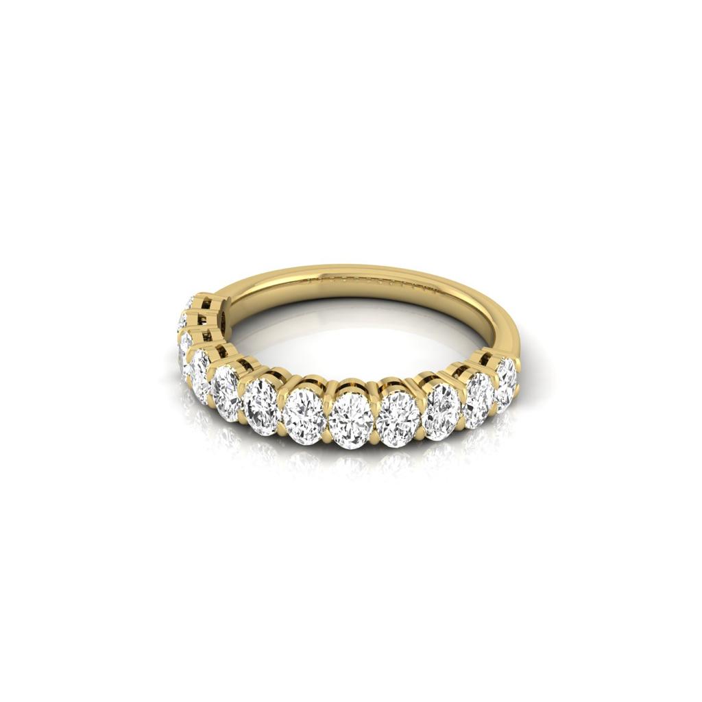 The Half Diamond Eternity Ring in 18KT gold showcases round VS clarity diamonds set along the band. These evenly spaced gems catch and reflect light beautifully, enhancing the rings luxurious elegance against a plain white backdrop.