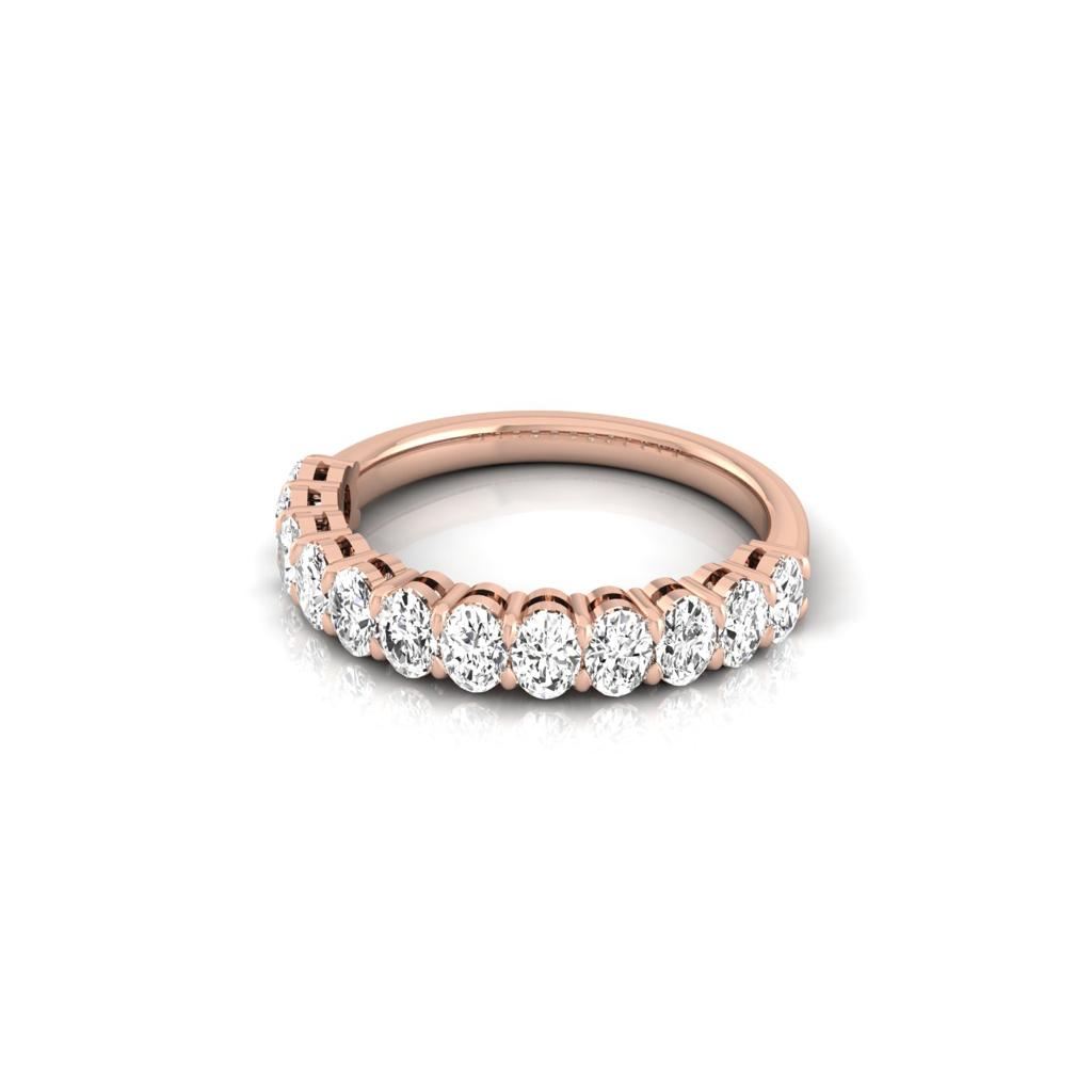 The Half Diamond Eternity Ring is a rose gold ring made from 18KT gold, adorned with a row of round sparkling diamonds with VS clarity, all presented on a plain white background.