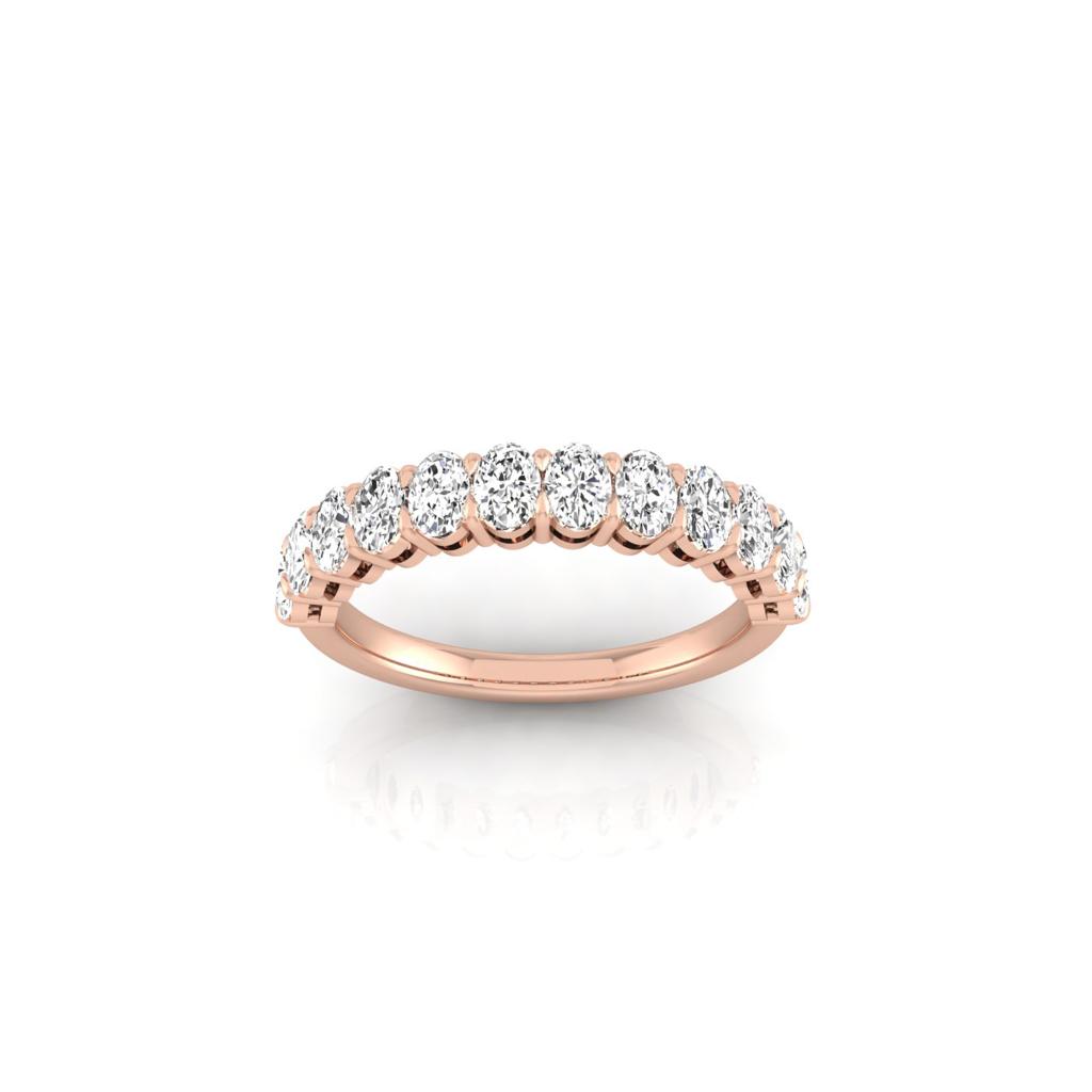 The Half Lab Grown Diamond Eternity Ring, crafted from 18KT rose gold and adorned with a row of round, sparkling diamonds, rests elegantly on a reflective white surface.