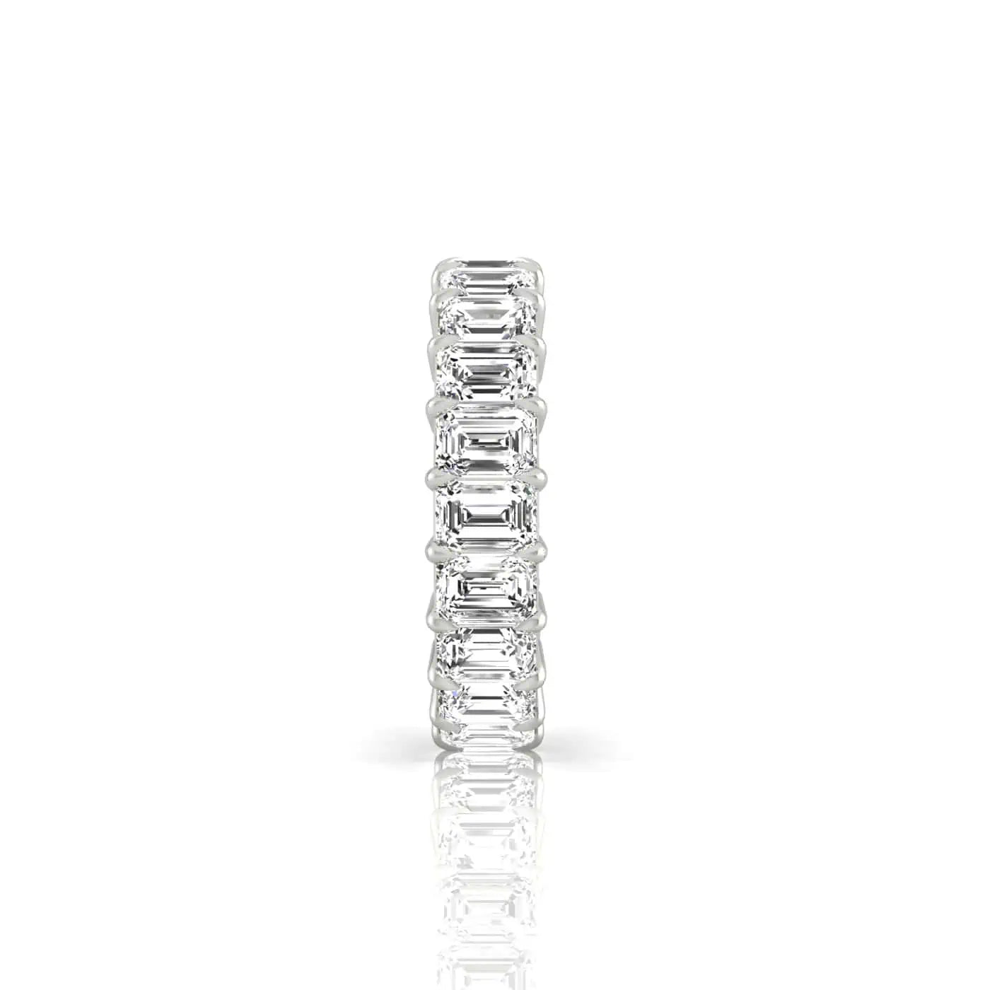 The Full Diamond Eternity Ring showcases a side view of its silver band featuring a continuous row of emerald-cut diamonds in prong settings. Crafted from 18KT Gold, its reflective surface amplifies the sparkle and brilliance of custom carat weights.