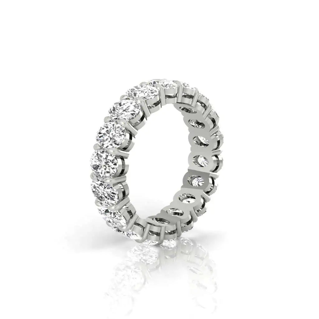 The Full Diamond Eternity Ring from Janet Heller Fine Jewelry, crafted in 18KT gold, features evenly spaced diamonds offered in various shapes and custom carat weights. The color of the diamonds is F and the clarity is VS. This is the perfect wedding band to be worn alone or stacked with your engagement ring.