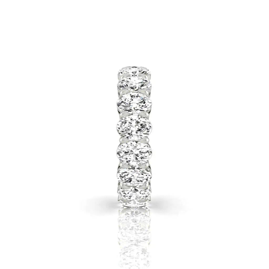 The Full Lab Grown Diamond Eternity Ring from Janet Heller Fine Jewelry, crafted in 18KT gold, features evenly spaced diamonds offered in various shapes and custom carat weights. The color of the diamonds is F and the clarity is VS. This is the perfect wedding band to be worn alone or stacked with your engagement ring.