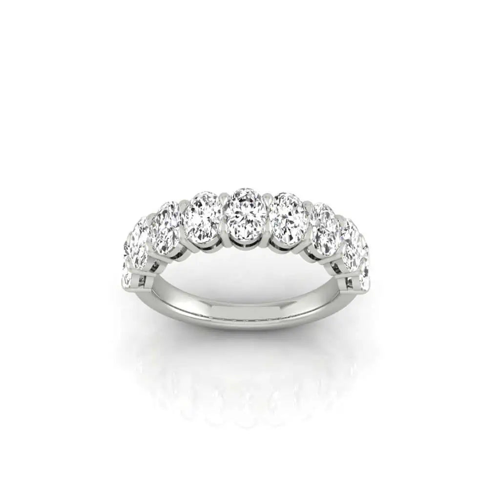 The Half Diamond Eternity Ring, a silver band adorned with round VS Clarity diamonds, is elegantly showcased on a white background.