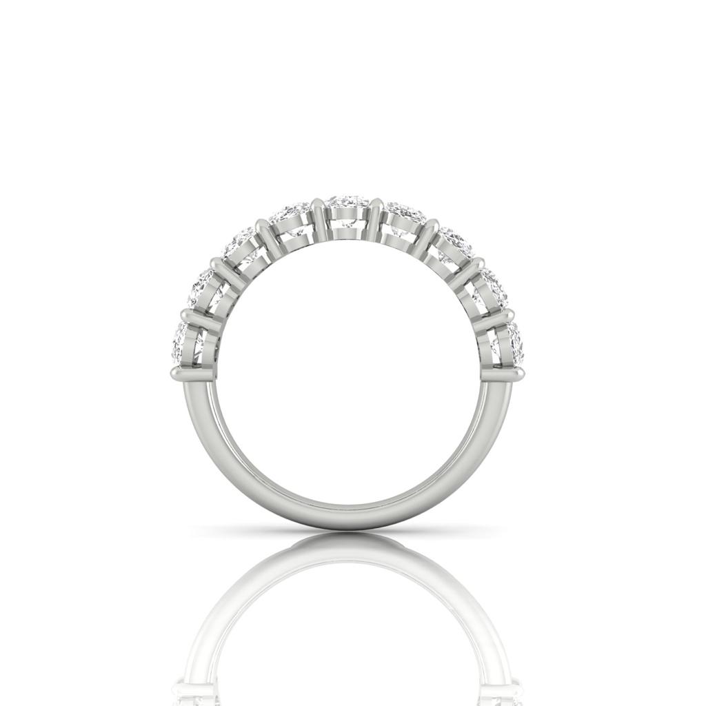 The Half Diamond Eternity Rings side view features a row of round-cut diamonds in prongs on the top half, shining with VS Clarity. The ring stands upright, displaying an elegant reflection beneath.