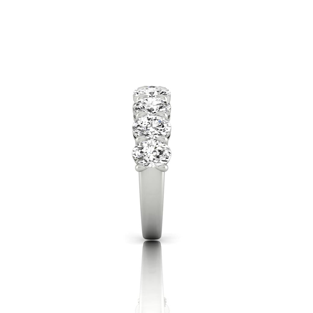 The Half Diamond Eternity Ring features an 18KT gold band with five round, VS Clarity diamonds set in a vertical alignment. The side view against a plain white background accentuates the rings simplicity and elegance.