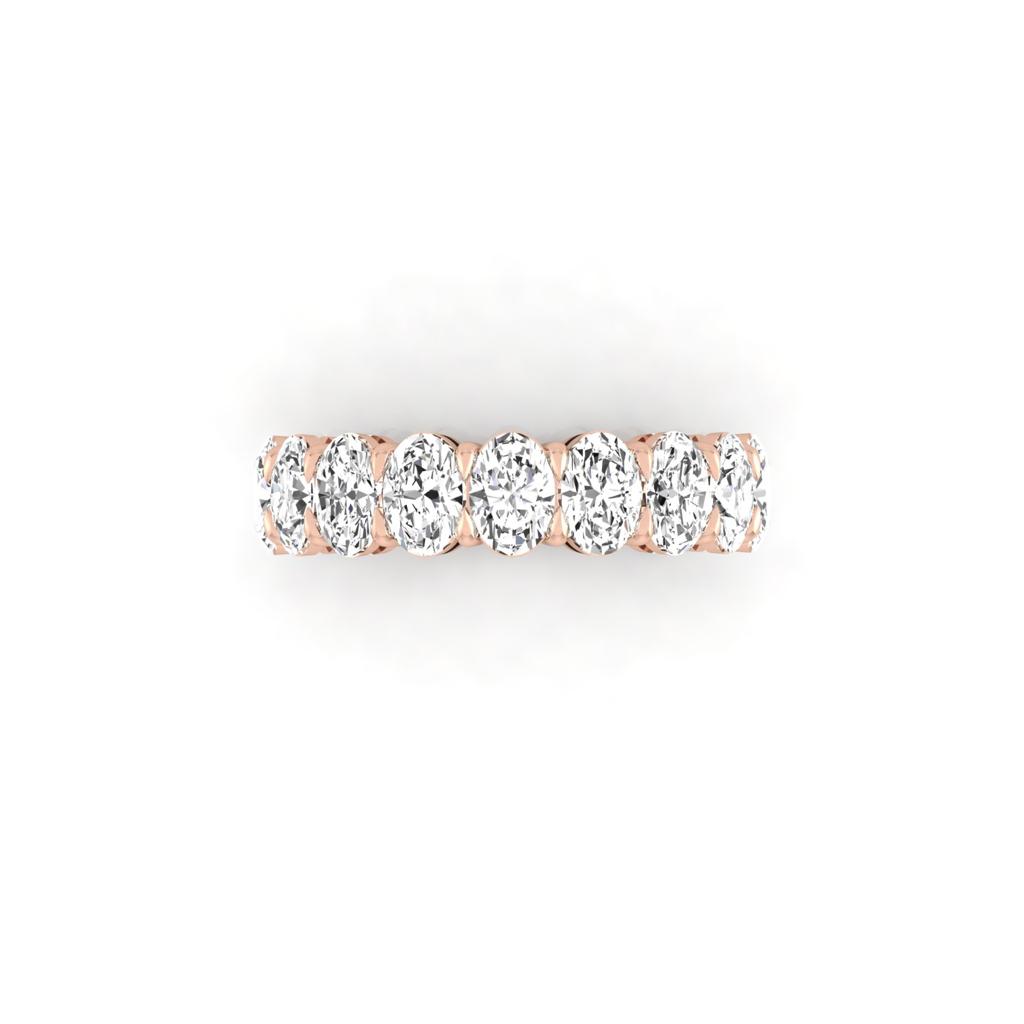 The Half Diamond Eternity Ring is an 18KT Gold masterpiece, showcasing oval-cut diamonds with exquisite VS Clarity arranged in a stunning row. This ring embodies timeless elegance and sophistication on a pristine white background.