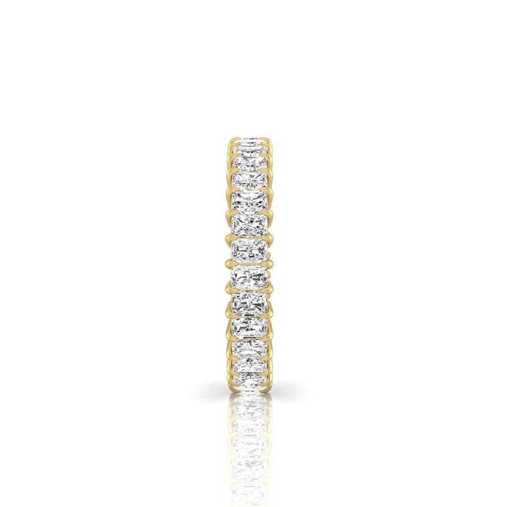 The Full Lab Grown Diamond Eternity Ring, set against a pristine white backdrop, features a row of dazzling diamonds in 18KT gold. Its slender elegance is highlighted by F Color VS Clarity, with a reflective surface that enhances its graceful design.
