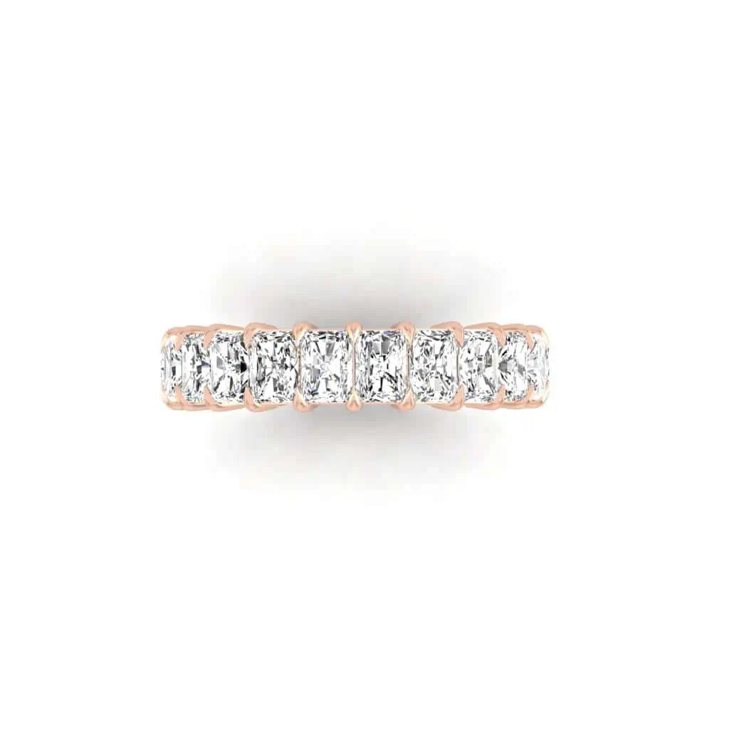 The Full Diamond Eternity Ring, crafted from luxurious 18KT gold, showcases a row of rectangular clear stones with F Color and VS Clarity elegantly set along its top, presented on a white background.