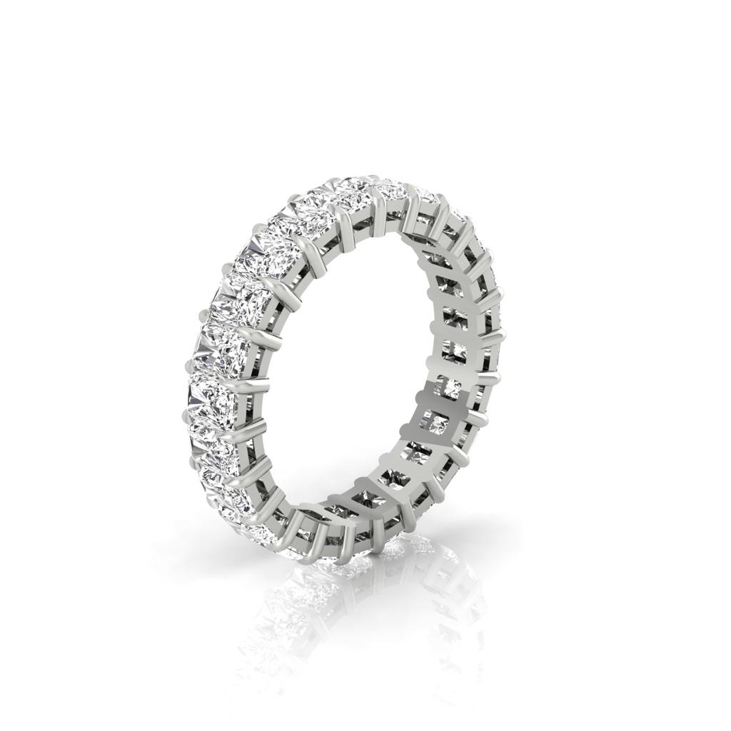 The Full Lab Grown Diamond Eternity Ring features a silver band adorned with round cut diamonds in F Color VS Clarity, encased by prongs and extending around the entire band, creating a brilliant glisten against the white background with its shadow below.