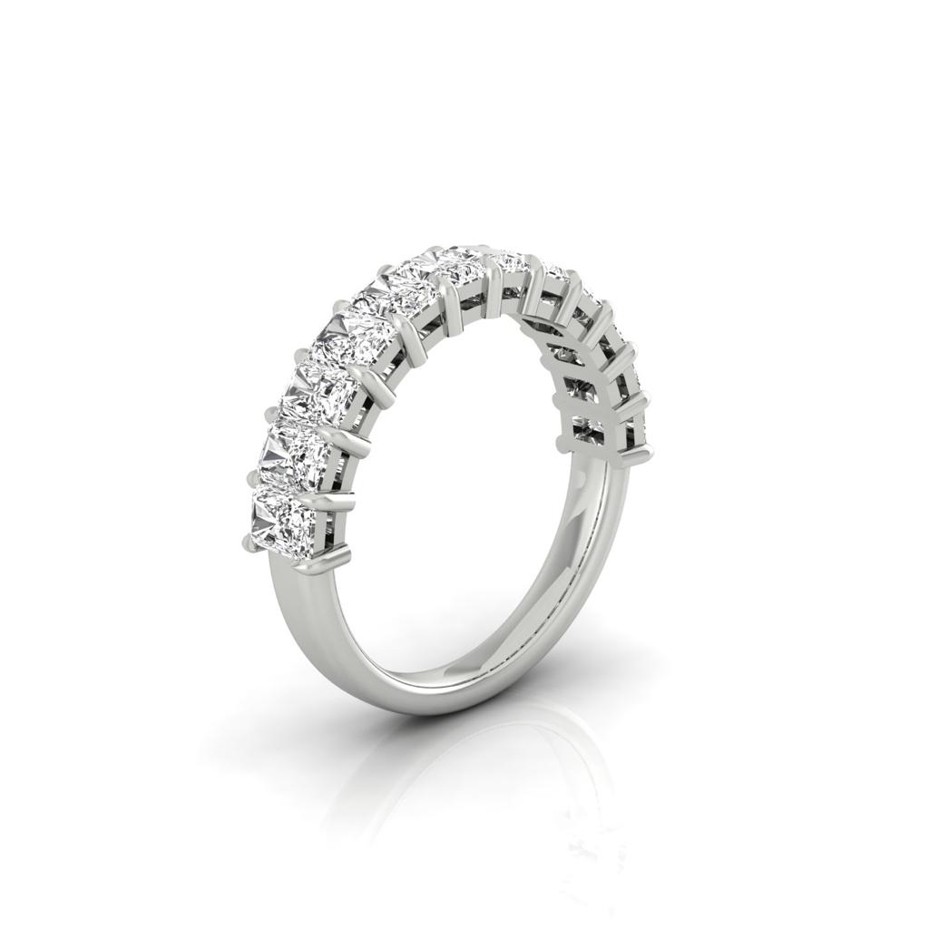The Half Lab Grown Diamond Eternity Ring from Janet Heller Fine Jewelry, crafted in 18KT gold, features a row of evenly spaced diamonds offered in various shapes and custom carat weights. The color of the diamonds is F and the clarity is VS. This is the perfect wedding band to be worn alone or stacked with your engagement ring.