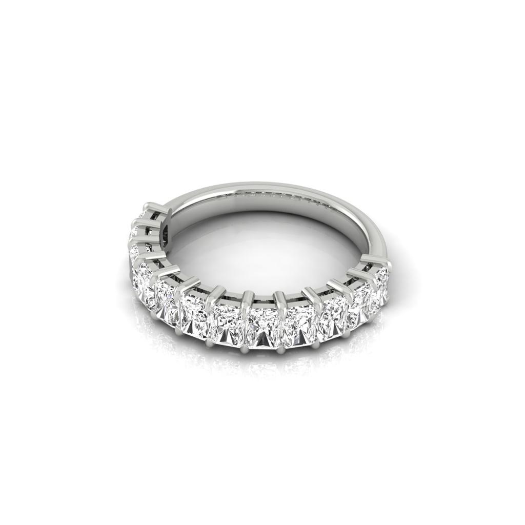 The Half Lab Grown Diamond Eternity Ring from Janet Heller Fine Jewelry, crafted in 18KT gold, features a row of evenly spaced diamonds offered in various shapes and custom carat weights. The color of the diamonds is F and the clarity is VS. This is the perfect wedding band to be worn alone or stacked with your engagement ring.