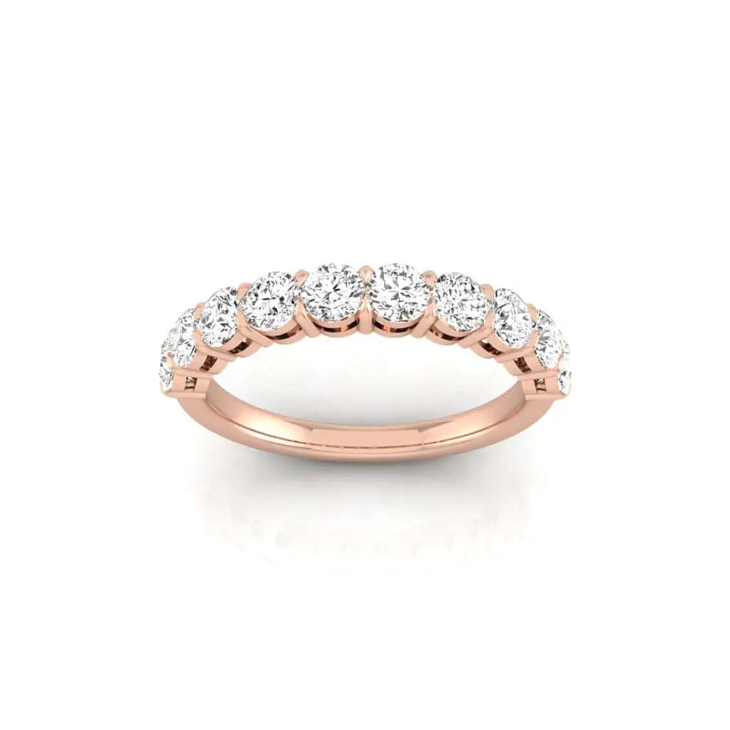 The Half Diamond Eternity Ring is crafted from 18KT rose gold and features a continuous row of round, sparkling diamonds with VS Clarity, elegantly presented against a plain white background.