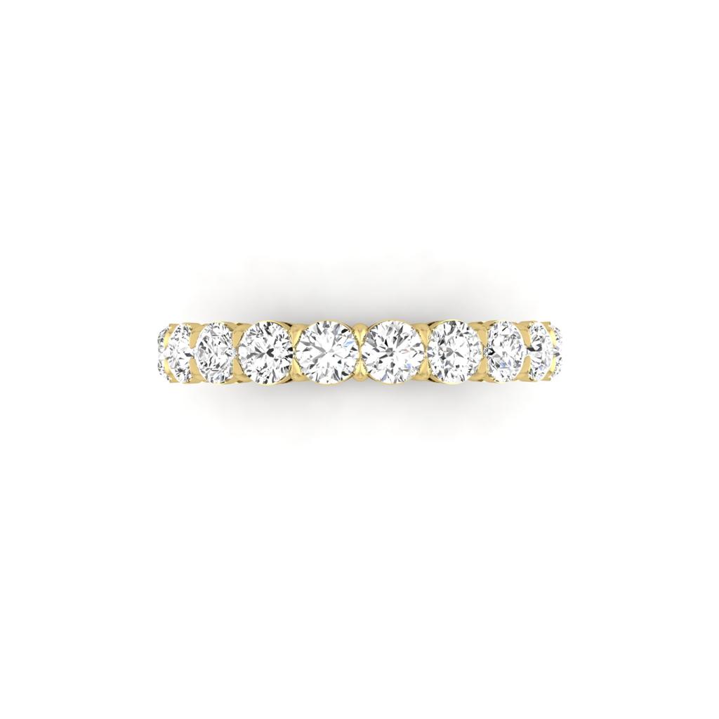 The Half Diamond Eternity Ring is an exquisite 18KT gold ring adorned with a row of round-cut diamonds featuring F Color and VS Clarity, prominently set across the band and displayed against a white background.