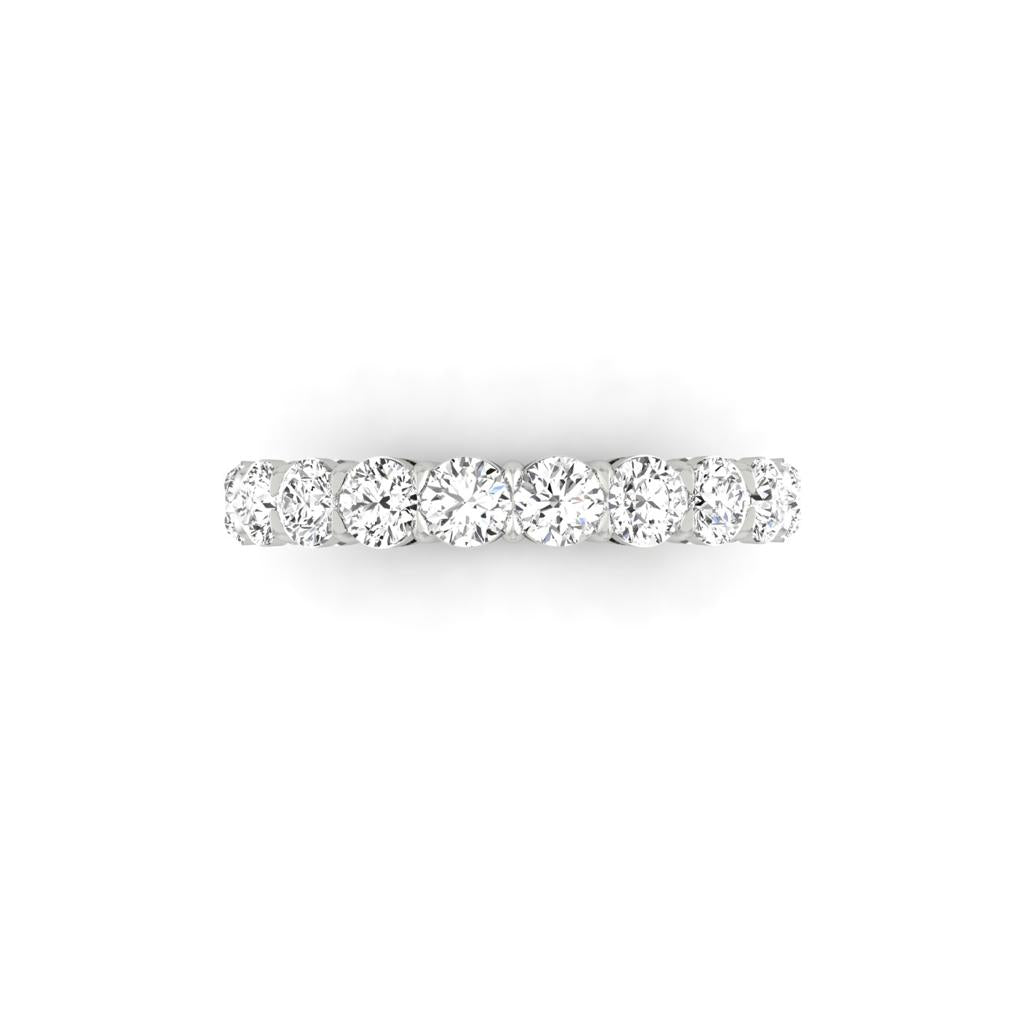 The Half Diamond Eternity Ring is crafted in 18KT white gold, featuring a row of round-cut diamonds with F color and VS clarity, elegantly set against a plain white background.