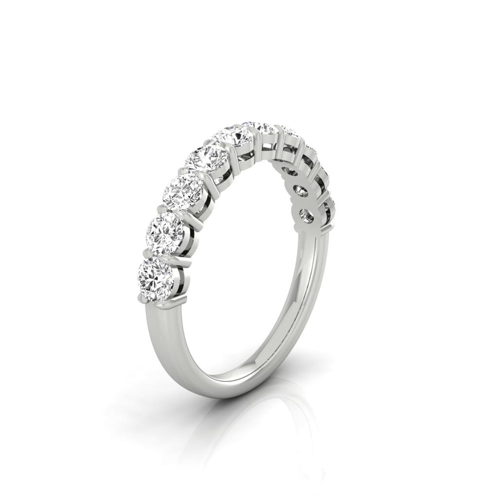 The Half Diamond Eternity Ring, in silver or 18KT gold, is elegantly crafted with five evenly spaced round diamonds that highlight the band with captivating sparkle. Positioned upright against a plain white background, it can feature custom carat weights for a personal touch.
