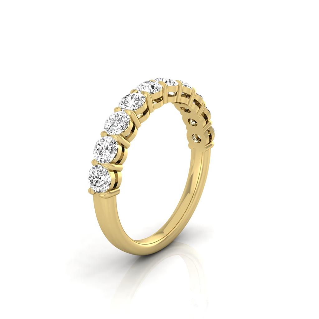 The Half Diamond Eternity Ring, elegantly crafted from luxurious 18KT gold, features nine sparkling round diamonds on the top half of the band. Positioned at an angle against a white background, it showcases its refined design.