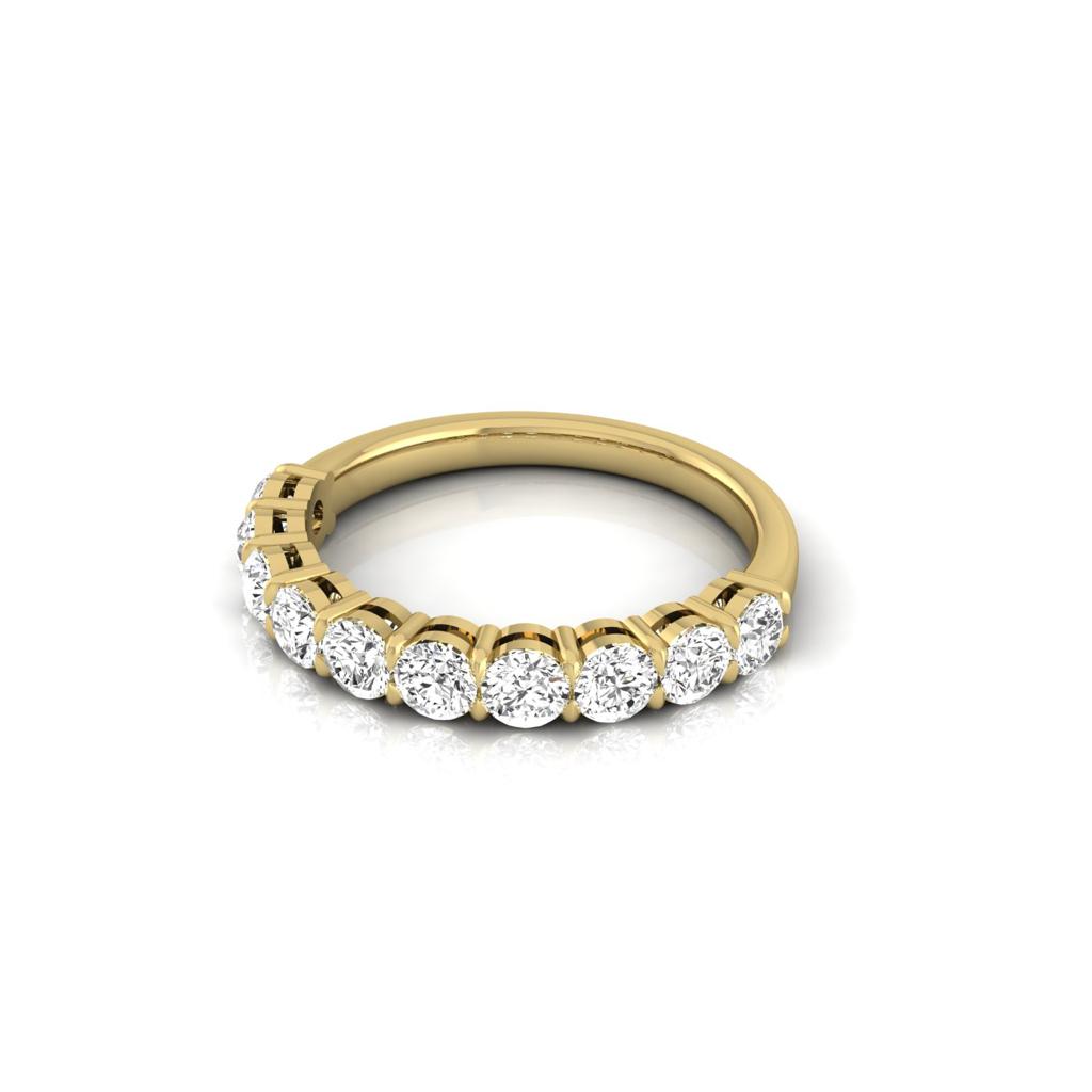 The Half Diamond Eternity Ring is an exquisite 18KT gold piece adorned with a row of round, sparkling diamonds set along the band, elegantly showcased on a plain white background.