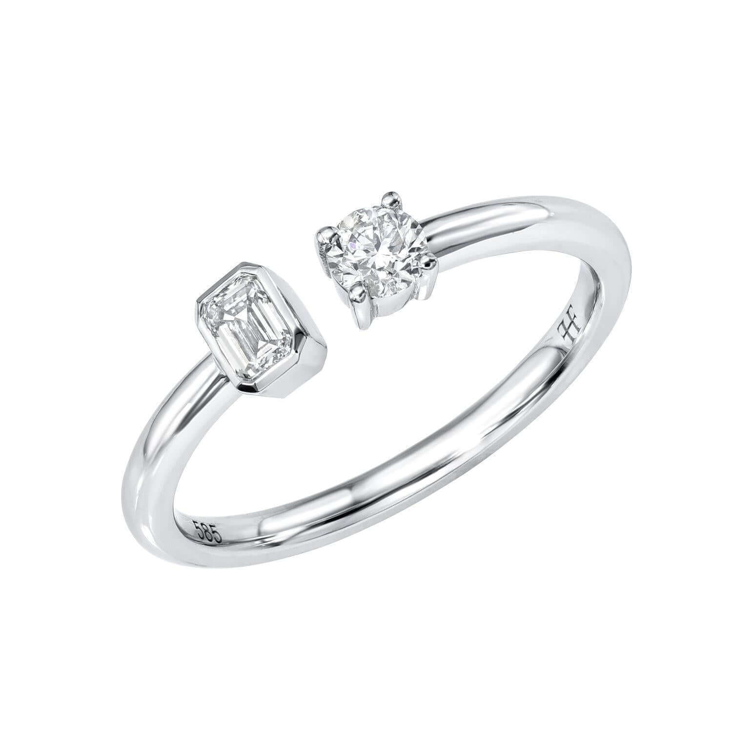 Introducing the Emerald & Round Toi Et Moi Ring: a silver open band ring showcasing a round diamond on one end and an emerald-cut diamond on the other, each secured in minimalist prongs. Inspired by classic Toi et Moi designs, this fine jewelry piece elegantly symbolizes love and connection.
