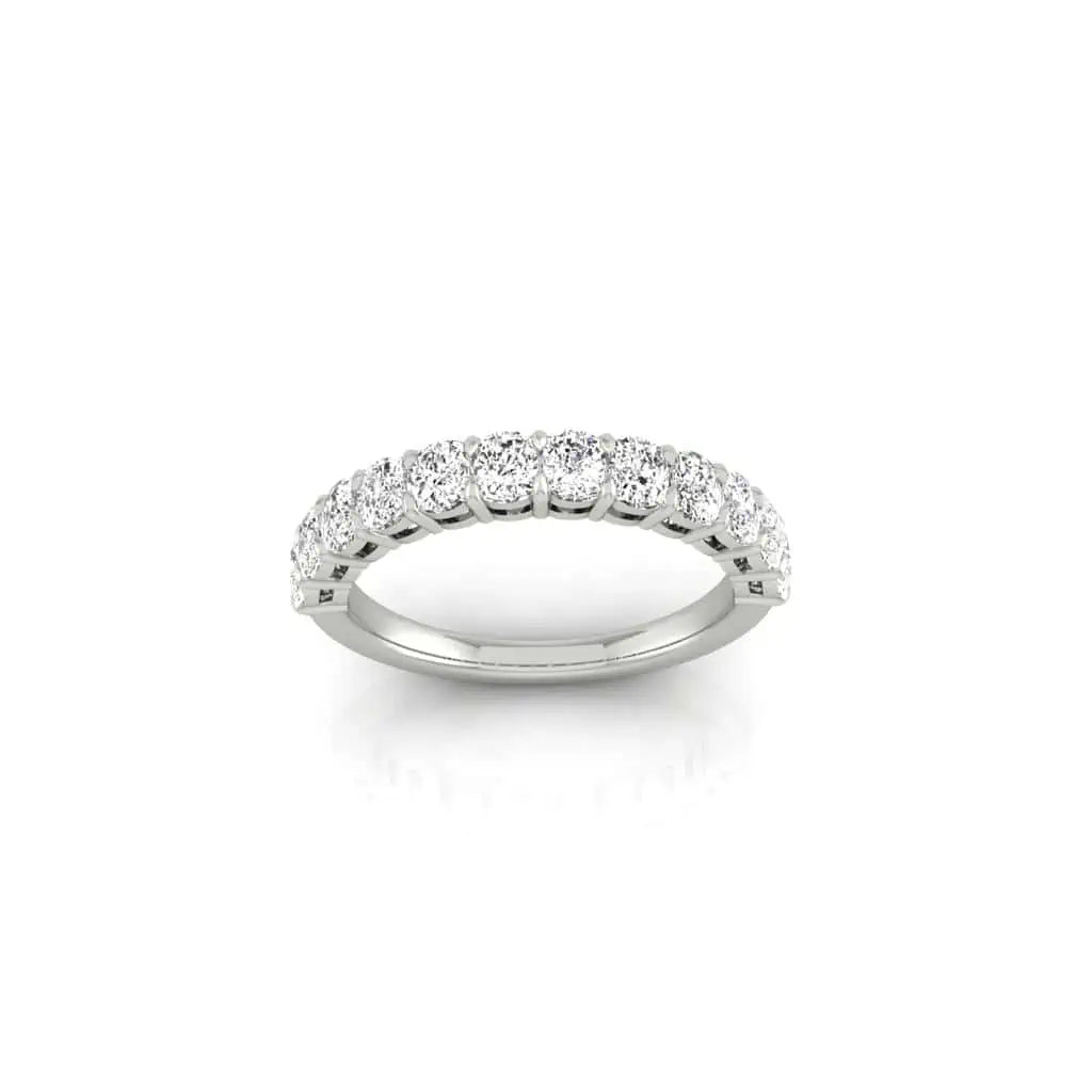 The Half Diamond Eternity Ring, crafted in silver and adorned with a row of nine sparkling VS Clarity diamonds, shines brilliantly against a plain white background.