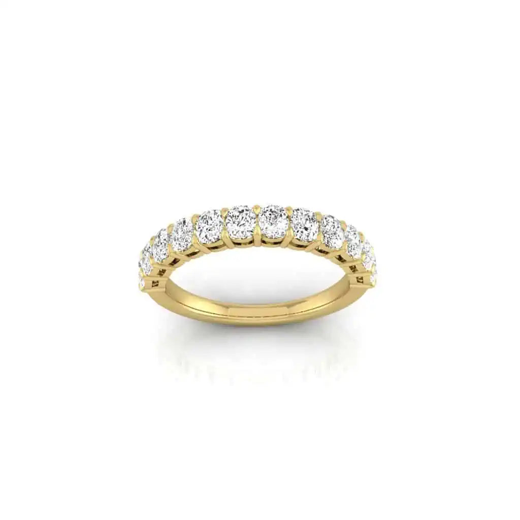 The Half Diamond Eternity Ring is an elegant 18KT gold band, showcasing a row of sparkling round diamonds with VS clarity, set against a plain white background.