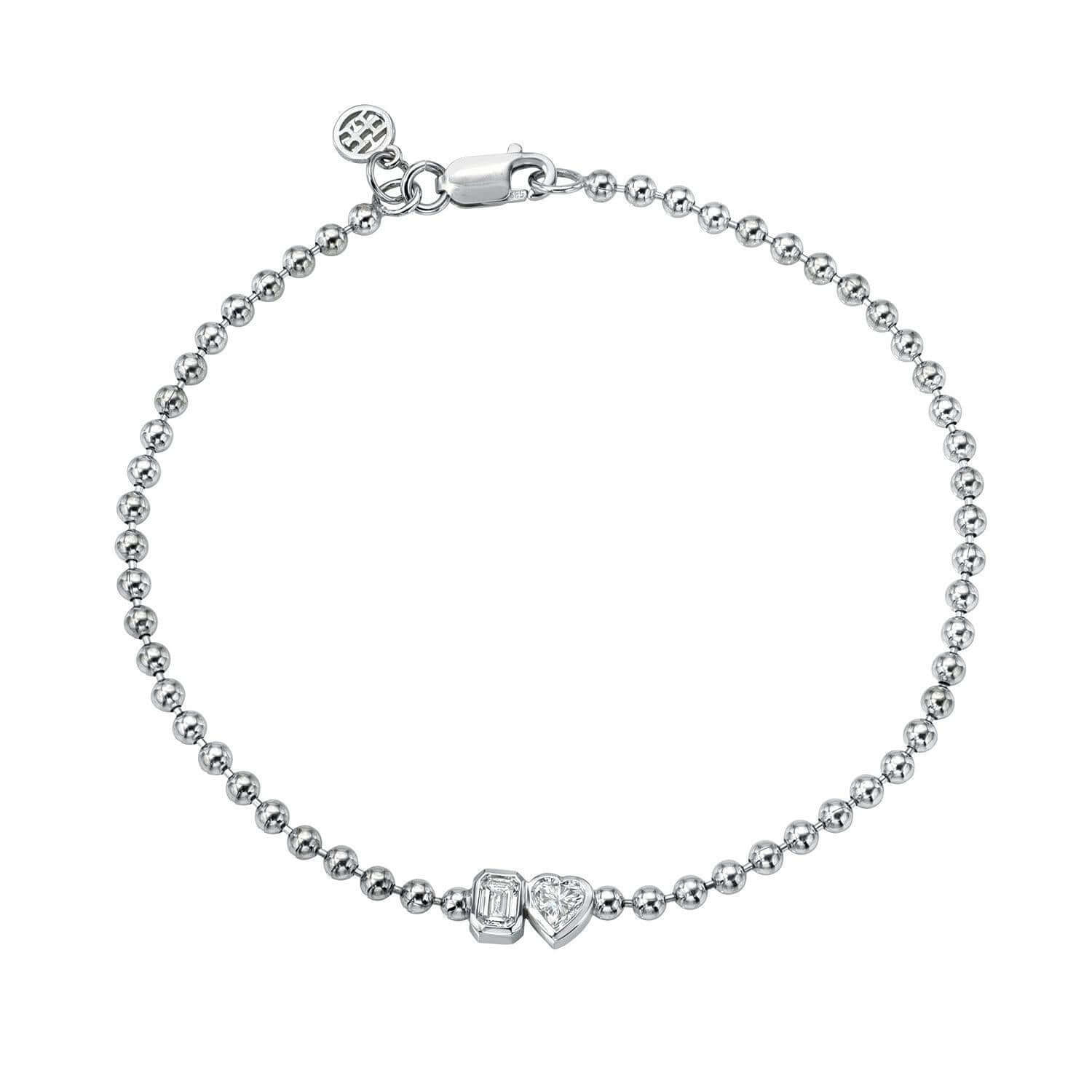 The Emerald & Heart Toi Et Moi Bracelet from Janet Heller Fine Jewelry, is crafted in 14KT gold and features heart and emerald-cut diamonds. The diamonds are 0.15 carats each and are in bezel settings. The bracelet can be worn on its own or stacked with others.