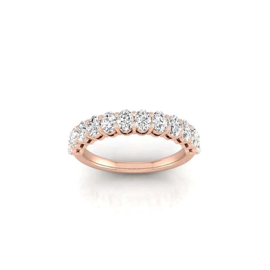 The Half Diamond Eternity Ring features a stunning 18KT rose gold band adorned with a single row of round-cut VS clarity diamonds, elegantly set against a pristine white background.