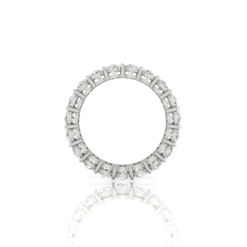 The Full Diamond Eternity Ring features a circle of evenly spaced, bezel-set diamonds with VS Clarity and F Color, crafted in 18KT Gold. Positioned vertically, its silver finish and sparkling reflection shine against a pristine white background.