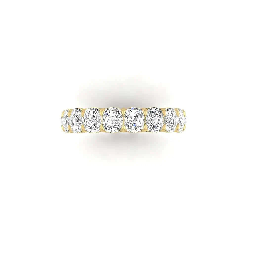 The Full Diamond Eternity Ring is an 18KT gold band with round, sparkling VS clarity diamonds set along the top against a plain white background.