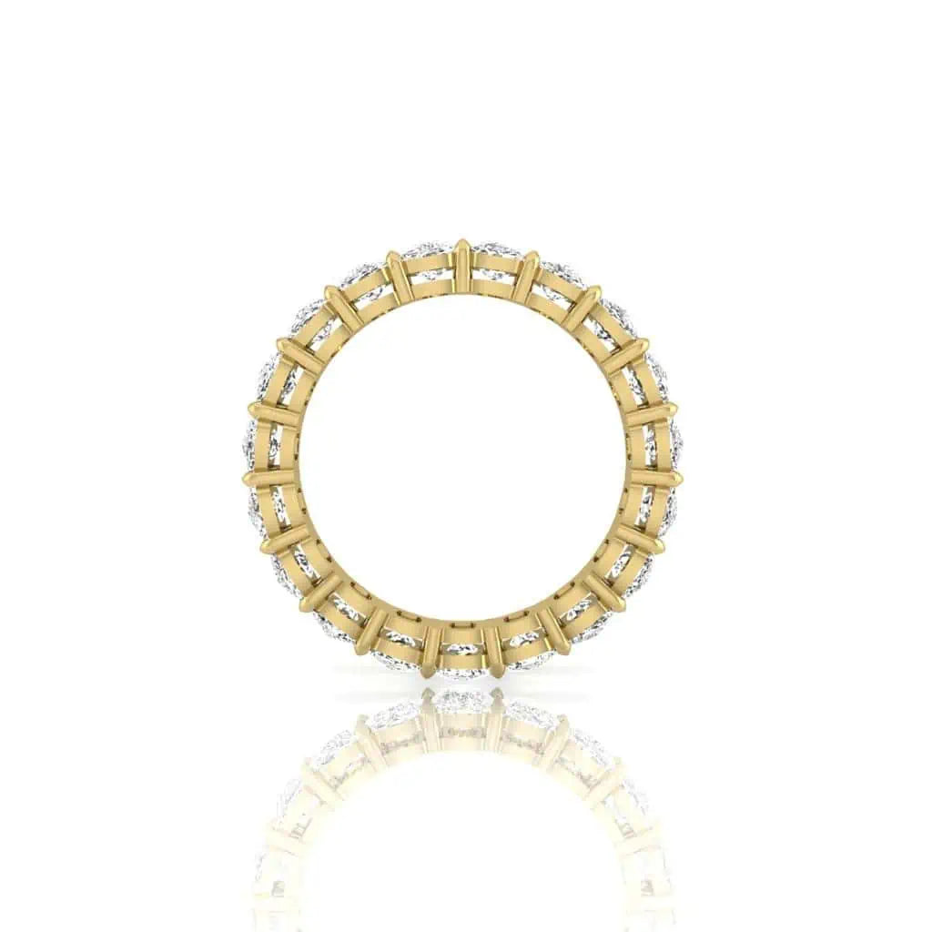 The Full Diamond Eternity Ring is an exquisite 18KT gold piece featuring a circular design with clear VS Clarity, F Color gemstones embedded alternately around the band. Displayed on a white background with soft reflections, this ring radiates elegance.