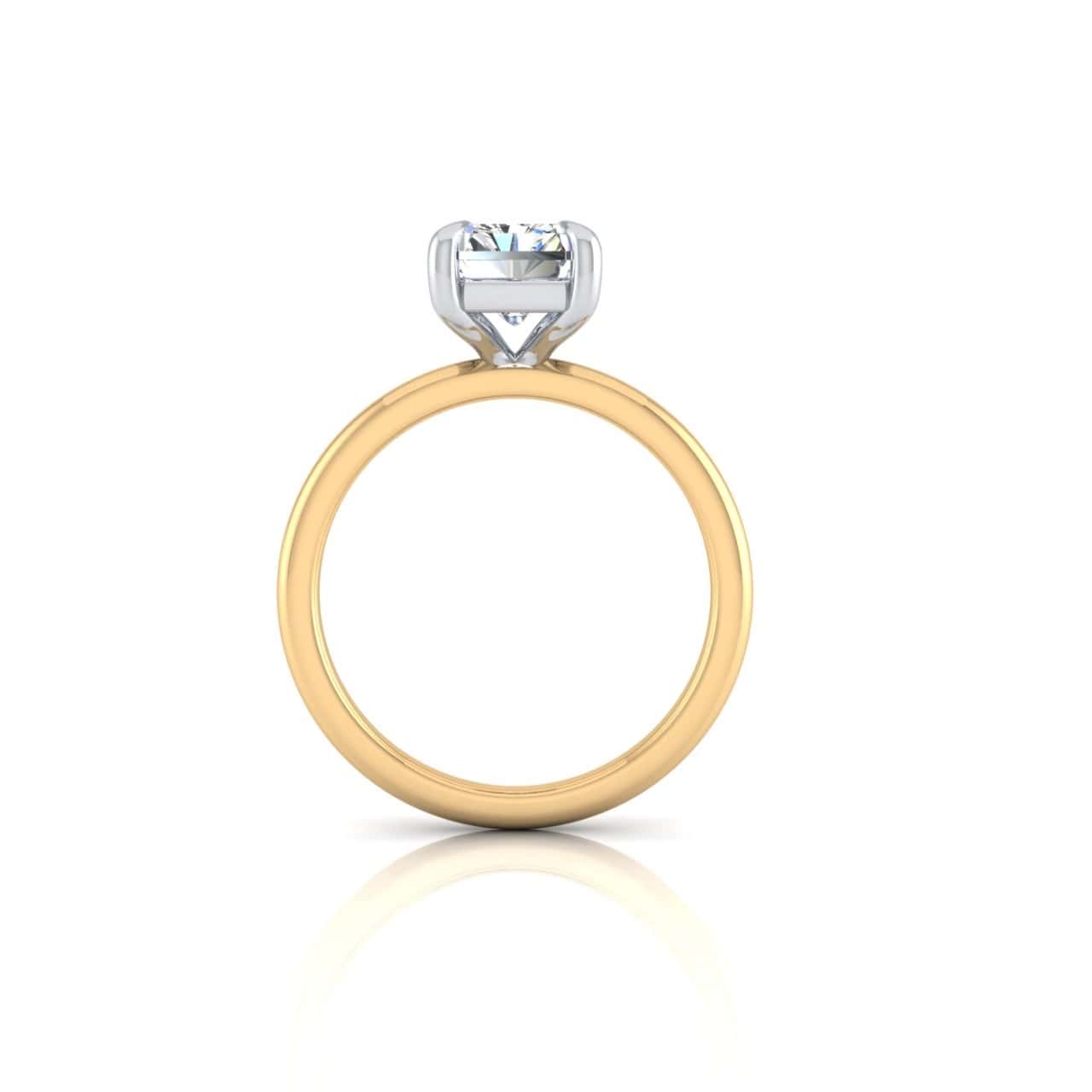 The Solitaire engagement ring showcases a round diamond in an 18KT white gold solitaire setting. Displayed upright against a pristine white background, its side view highlights the gemstones brilliance.