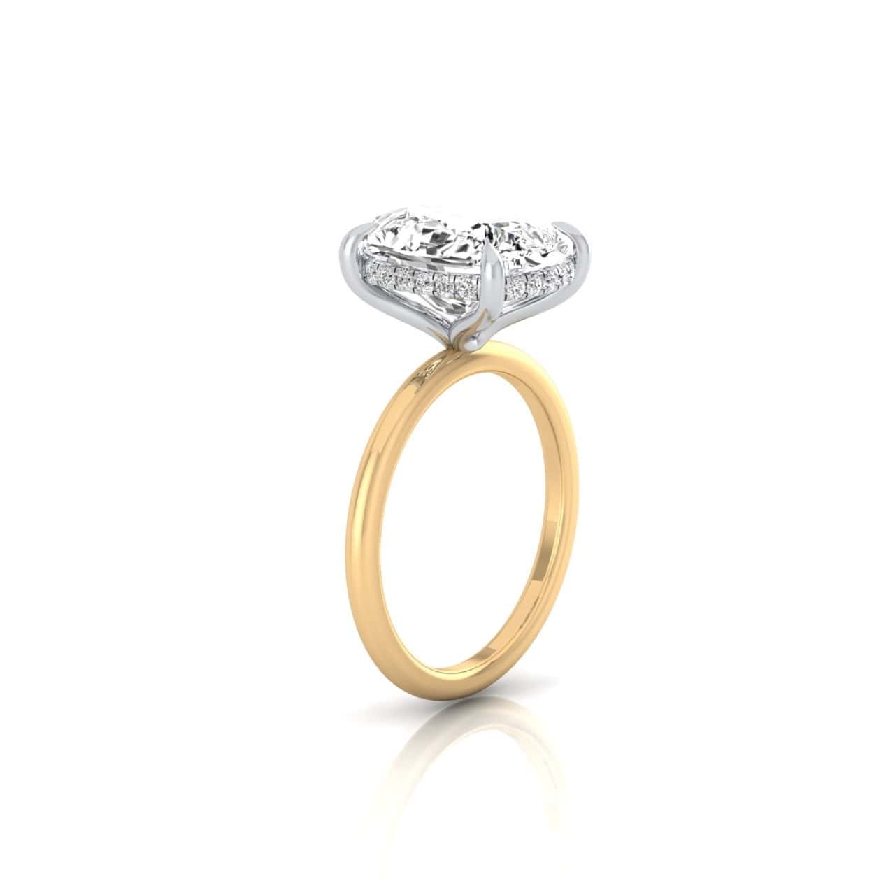The Solitaire + Hidden Halo ring features a heart-shaped diamond solitaire with a hidden halo of small diamonds, set on a polished gold band. It creates an elegant appearance against a plain white background.