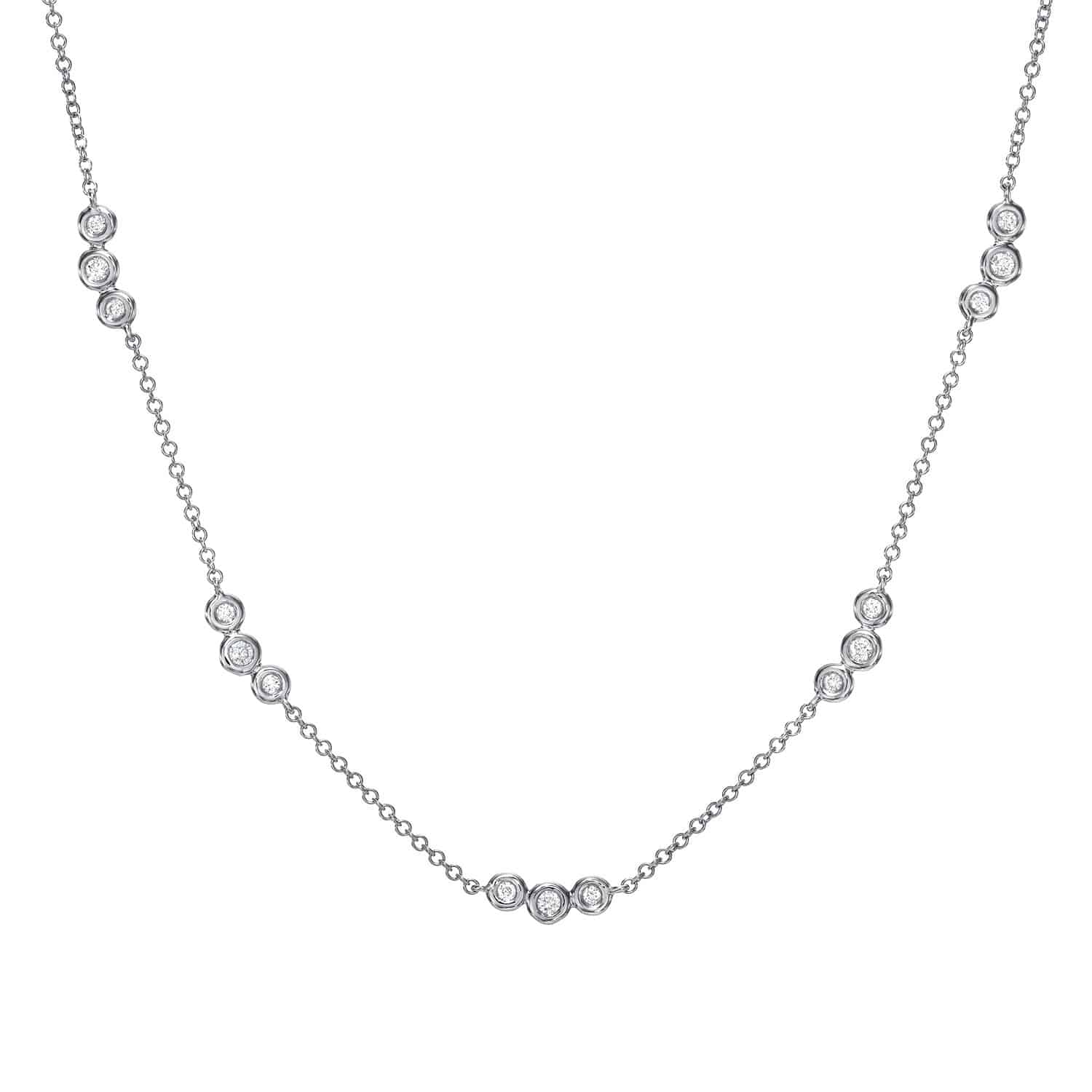 The Bezel Diamond Trio Station Necklace by Janet Heller Fine Jewelry is crafted in 14KT gold.  It features a gold chain with clusters of three small, round diamonds set in circular bezels linked by delicate chains.  The necklace can be worn alone or layered with other necklaces.