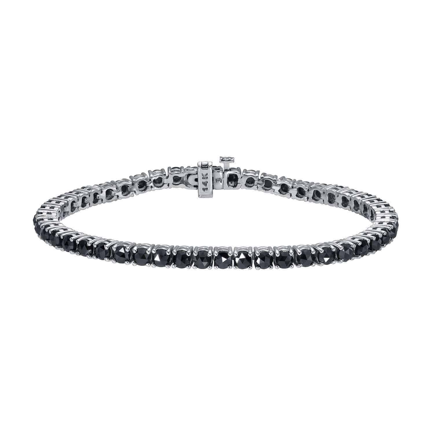 A striking Black Diamond Tennis Bracelet, priced at $5,565.00, features shimmering black diamonds set in silver and secured with a visible clasp—all showcased against a white background. This elegant piece is an exquisite offering from Janet Heller Fine Jewelry.