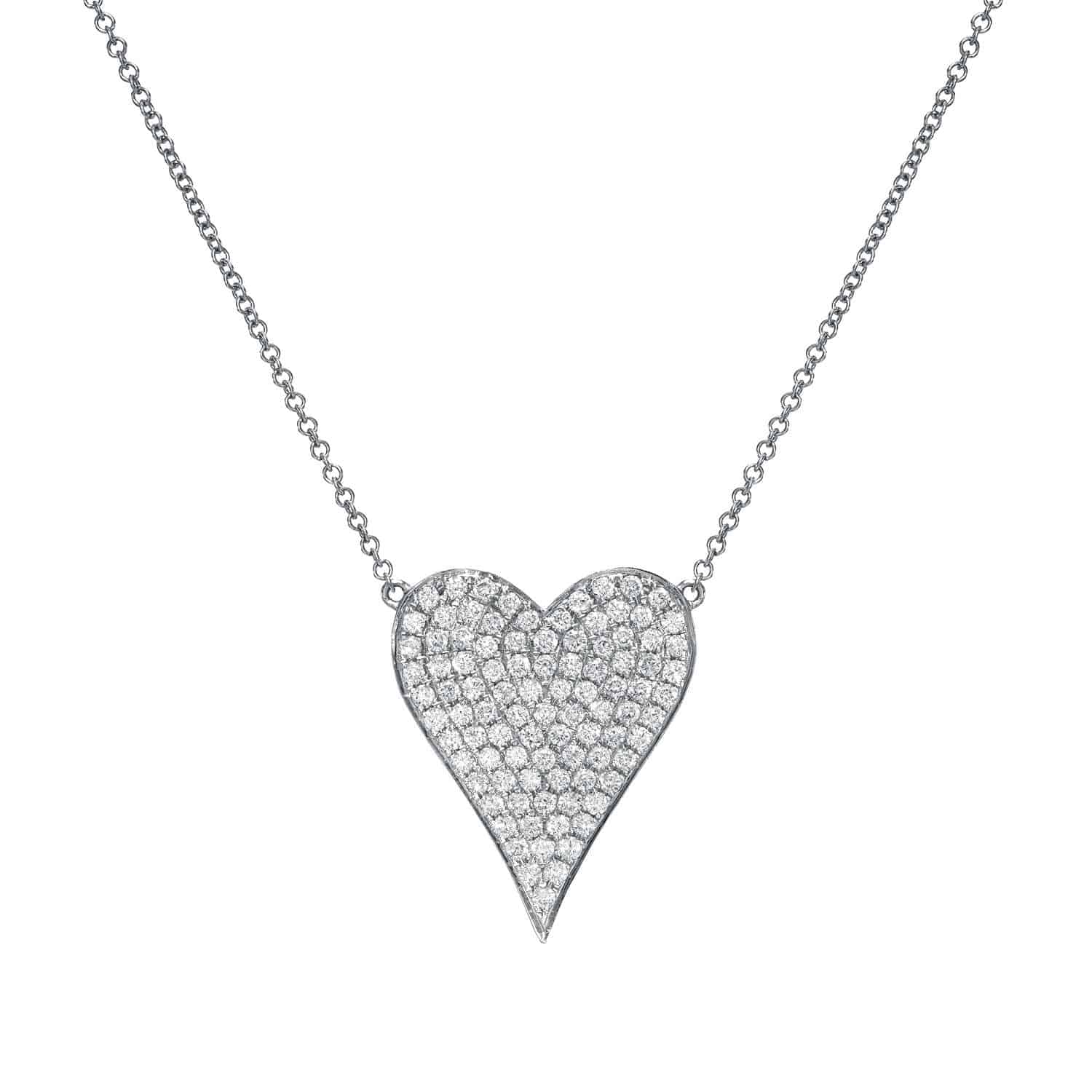 The Diamond Heart Alina Necklace features an asymmetrical heart-shaped pendant, fully encrusted with sparkling diamonds, suspended from a delicate silver chain against a white background—a timeless showcase of Janet Heller Fine Jewelry’s signature craftsmanship.