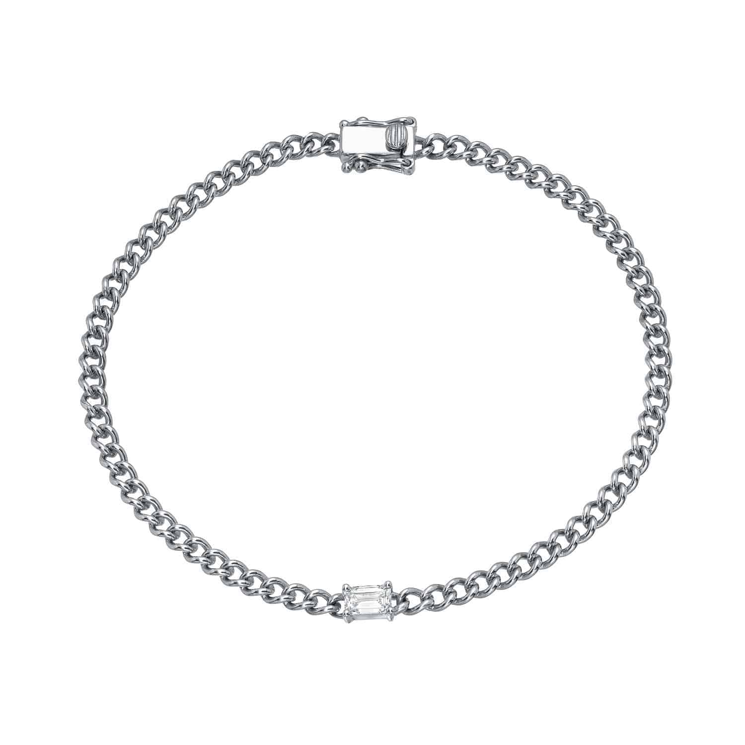 A delicate silver chain bracelet featuring an emerald-cut gemstone set at the center, complete with a clasp closure. The piece is named the Emerald Cut Aurora Bracelet.