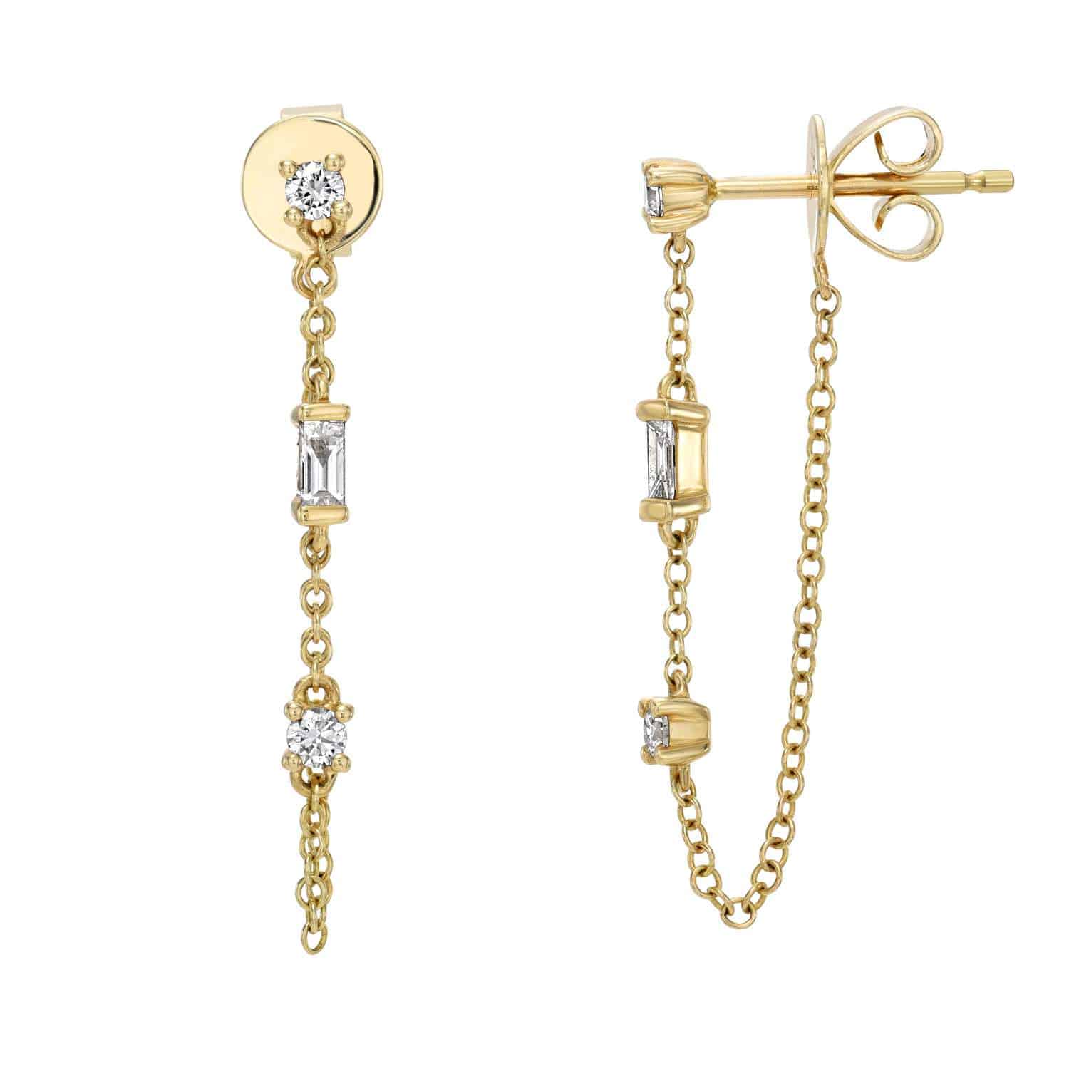 The Baguette Diamond Trio Chain Studs from Janet Heller Fine Jewelry are crafted in 14KT gold and feature a delicate chain with round and rectangular diamond settings. The dangling earrings can be worn alone or layered along the ear with other earrings.