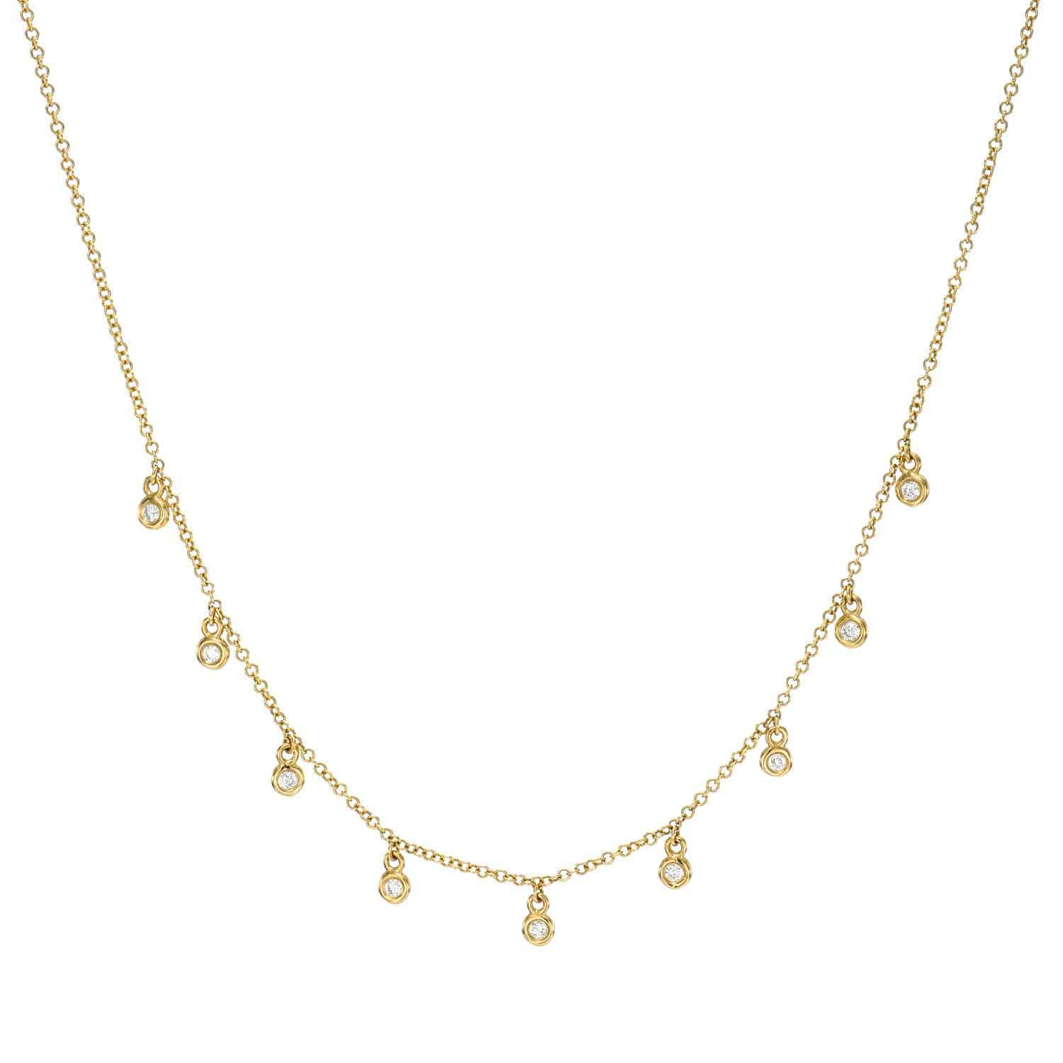 The Bezel Diamond Drop Necklace from Janet Heller Fine Jewelry showcases a delicate gold chain adorned with small round diamonds, evenly spaced and gracefully hanging along the front.
