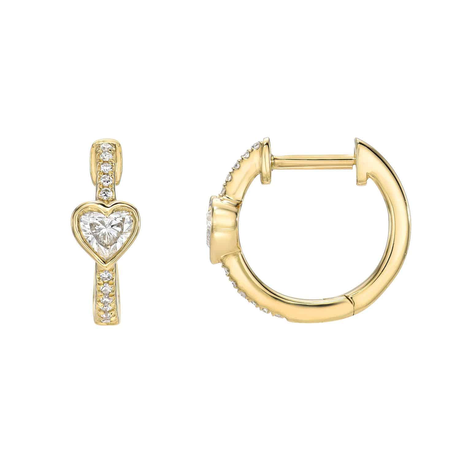 The Diamond Amore Huggies exemplify fine jewelry with a heart-shaped diamond center, bordered by a vertical line of small round diamonds. For inquiries or customization, one earring is shown front-facing and the other side-facing.