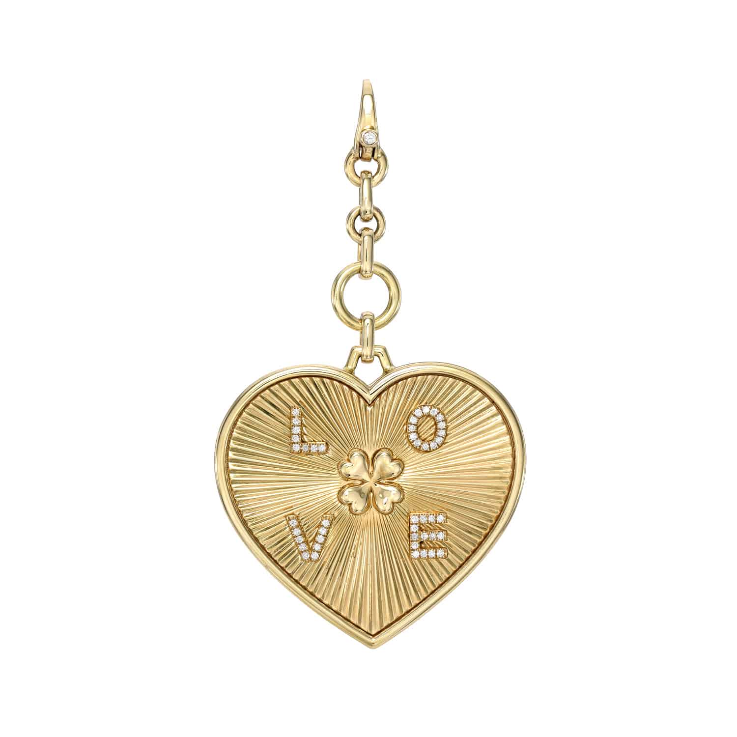 The Diamond Heart Kai Charm from Janet Heller Fine Jewelry is a gold, heart-shaped piece featuring a detailed pattern with a four-leaf clover. The word LOVE is adorned with sparkling gems. Its customizable and attached to a decorative chain link, ideal for personal styling.