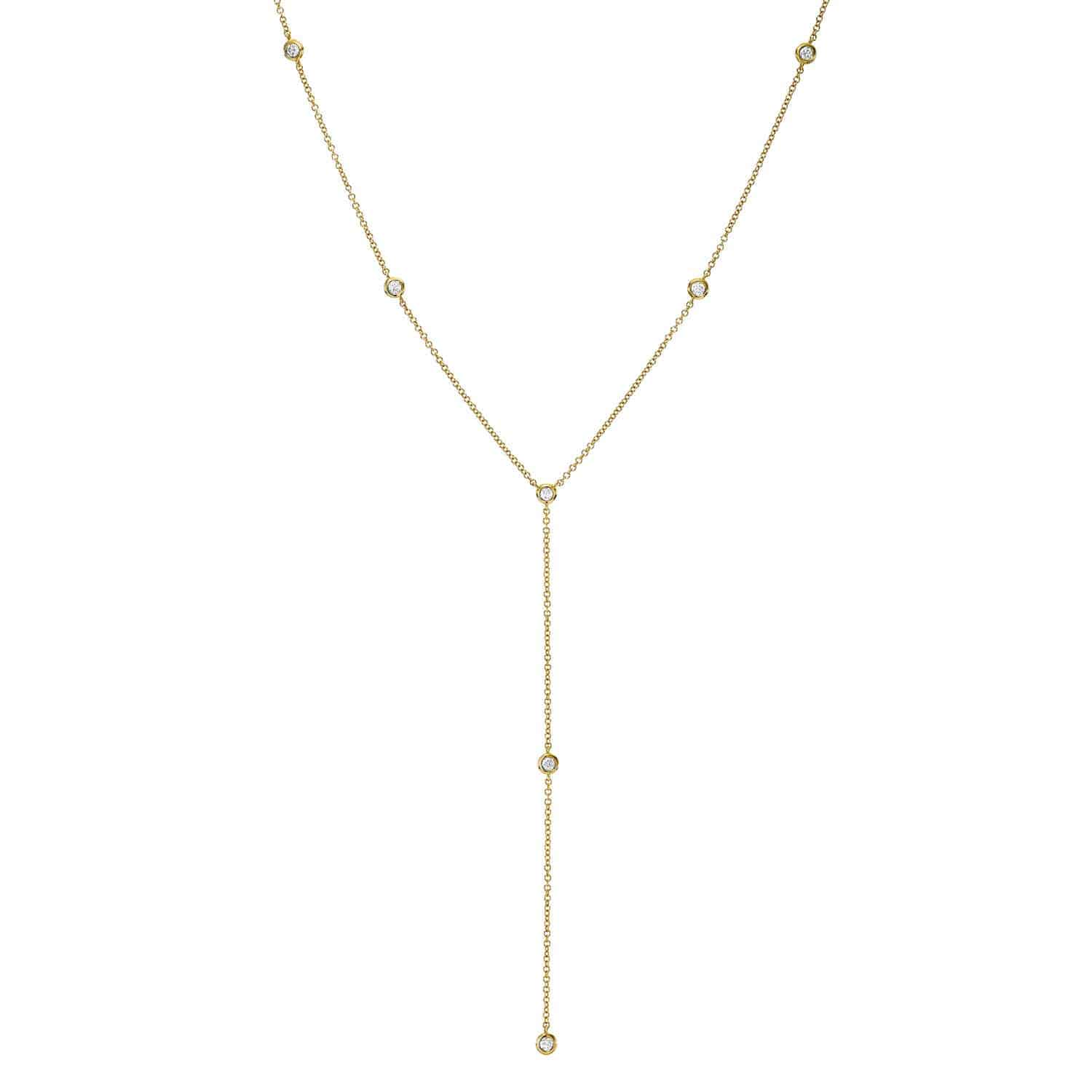 The Diamond Logan Lariat from Janet Heller Fine Jewelry is a delicate gold Y-shaped necklace featuring small round crystal accents evenly spaced along the chain, with a pendant section that elegantly extends downward for a chic and timeless design. Ideal for sophisticated style inquiries.