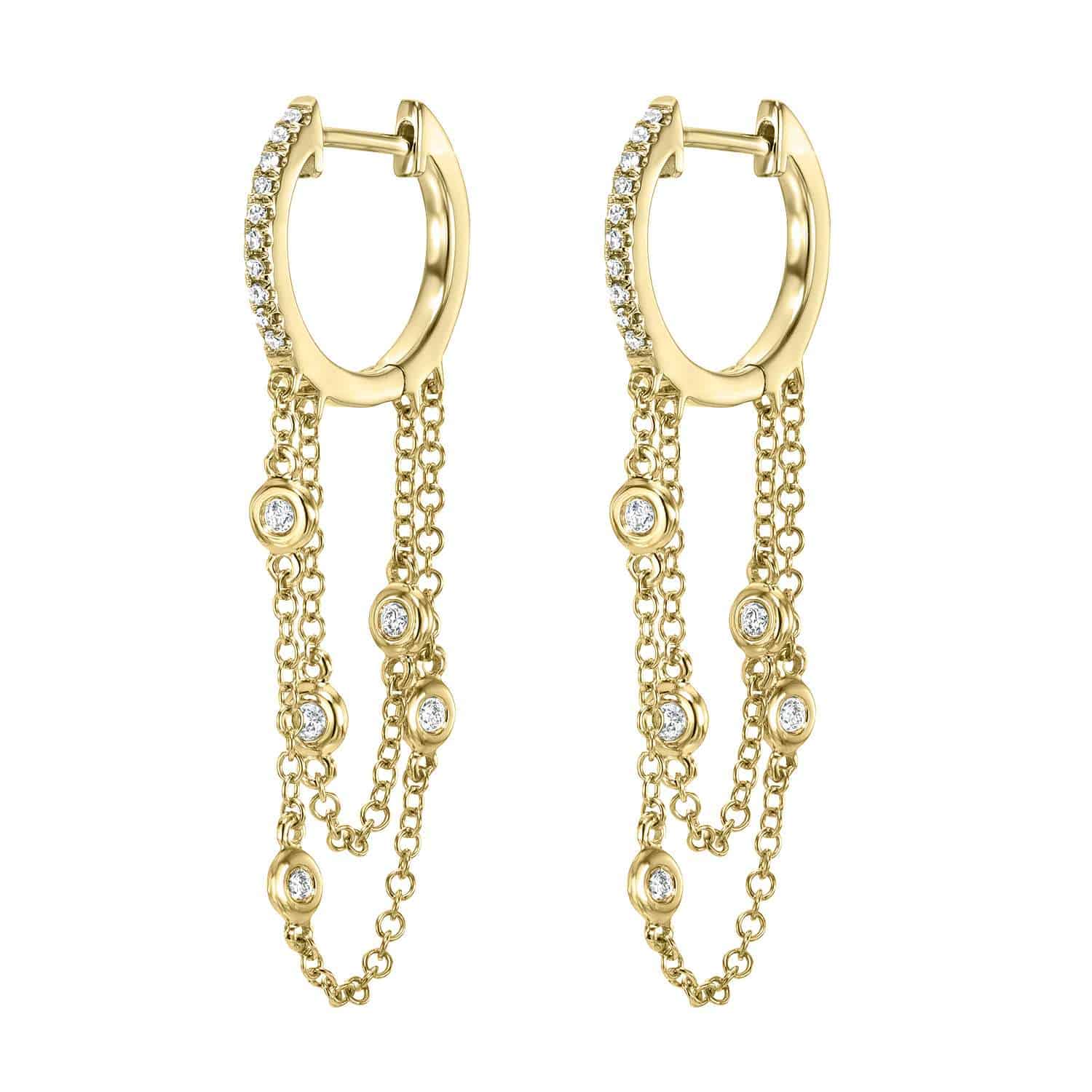 The Diamond Waterfall Huggies from Janet Heller Fine Jewelry are gold hoop earrings with cascading chains featuring small sparkling gems. Each earring has three dangling chains of varying lengths, adorned with circular gem settings for an elegant and sophisticated look.