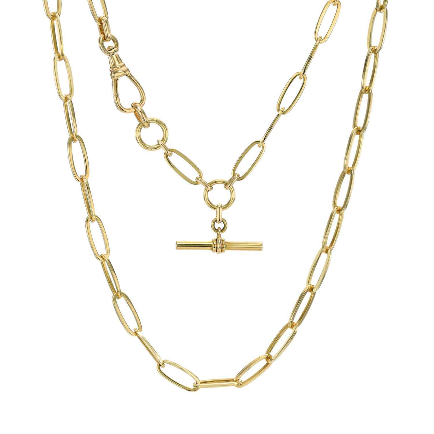 Two gold Florence Chain necklaces from Janet Heller Fine Jewelry with elongated oval links. One necklace features a T-bar pendant hanging from a circular clasp, while the other is a simple chain without any additional charms or adornment.