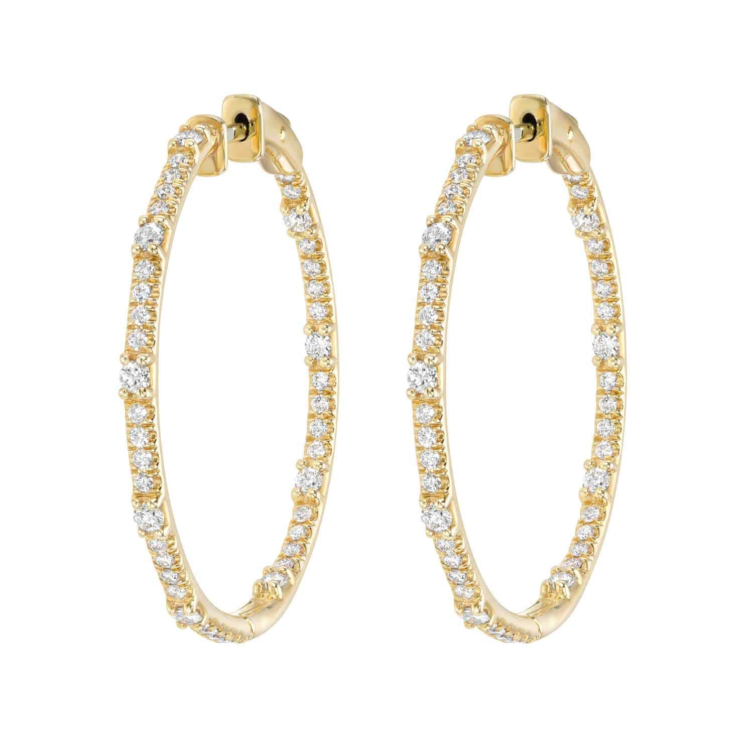 The Round Chandler Hoops from Janet Heller Fine Jewelry crafted in 14KT gold are adorned with small white diamonds. The diamonds are a total of 1.76 carats. The hoops can be worn alone or layered along the ear with other earrings.
