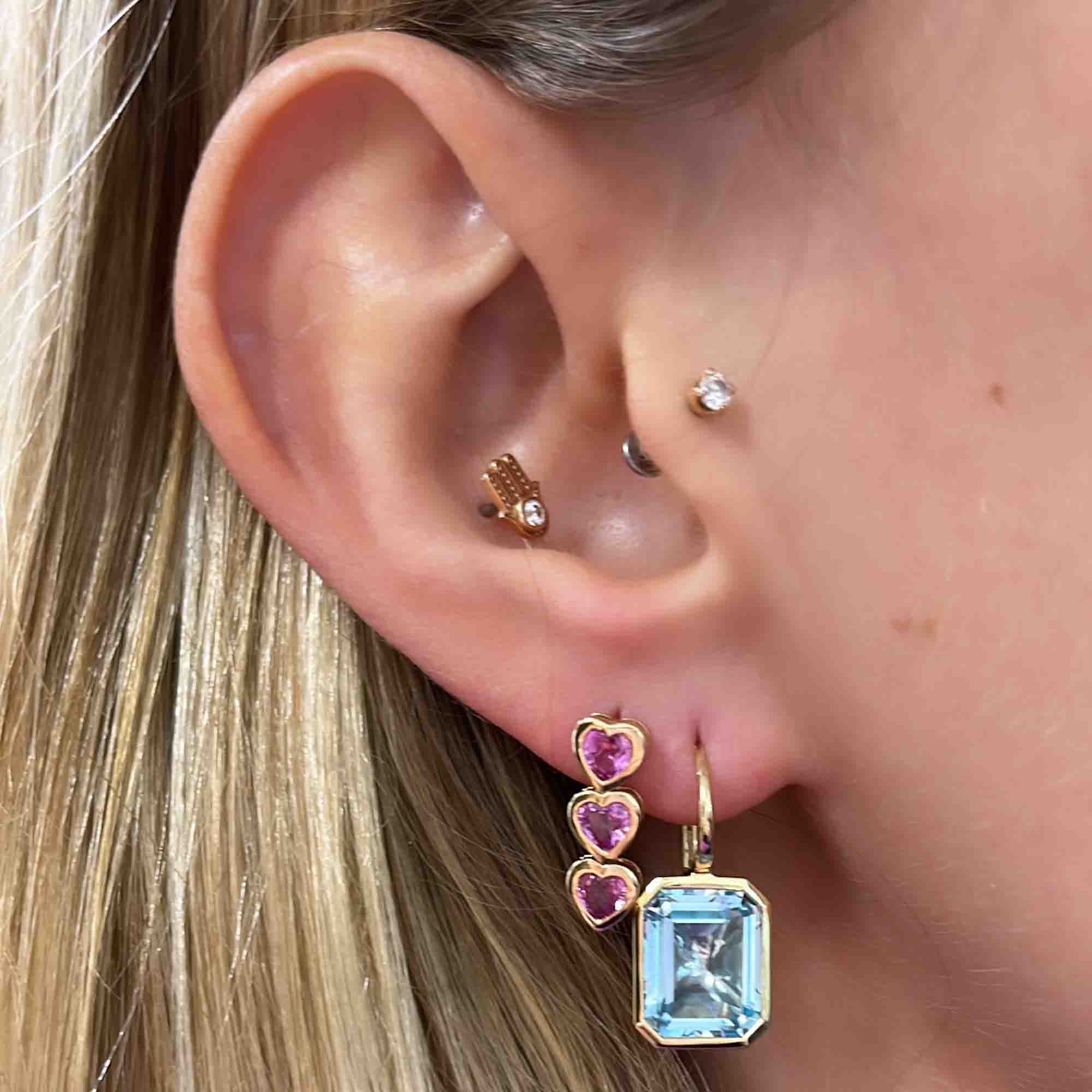 The Sky Blue Topaz Leverback Earrings from Janet Heller Fine Jewelry crafted in 14KT gold feature two blue topaz stones in an emerald-cut shape. The earrings can be worn alone or layered along the ear with other earrings.